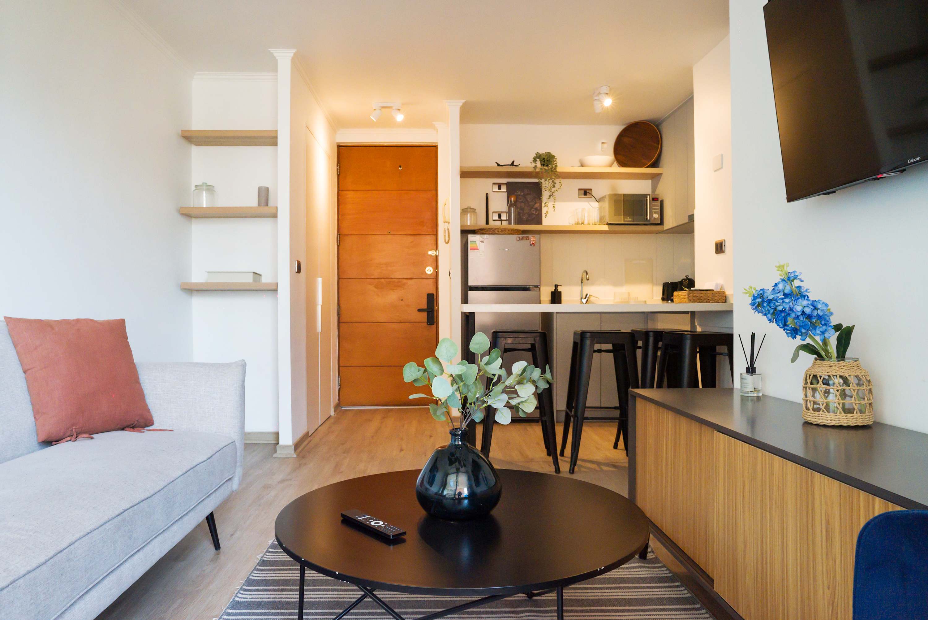 Modern living area with a sleek kitchen and cozy seating, perfect for relaxation and dining.