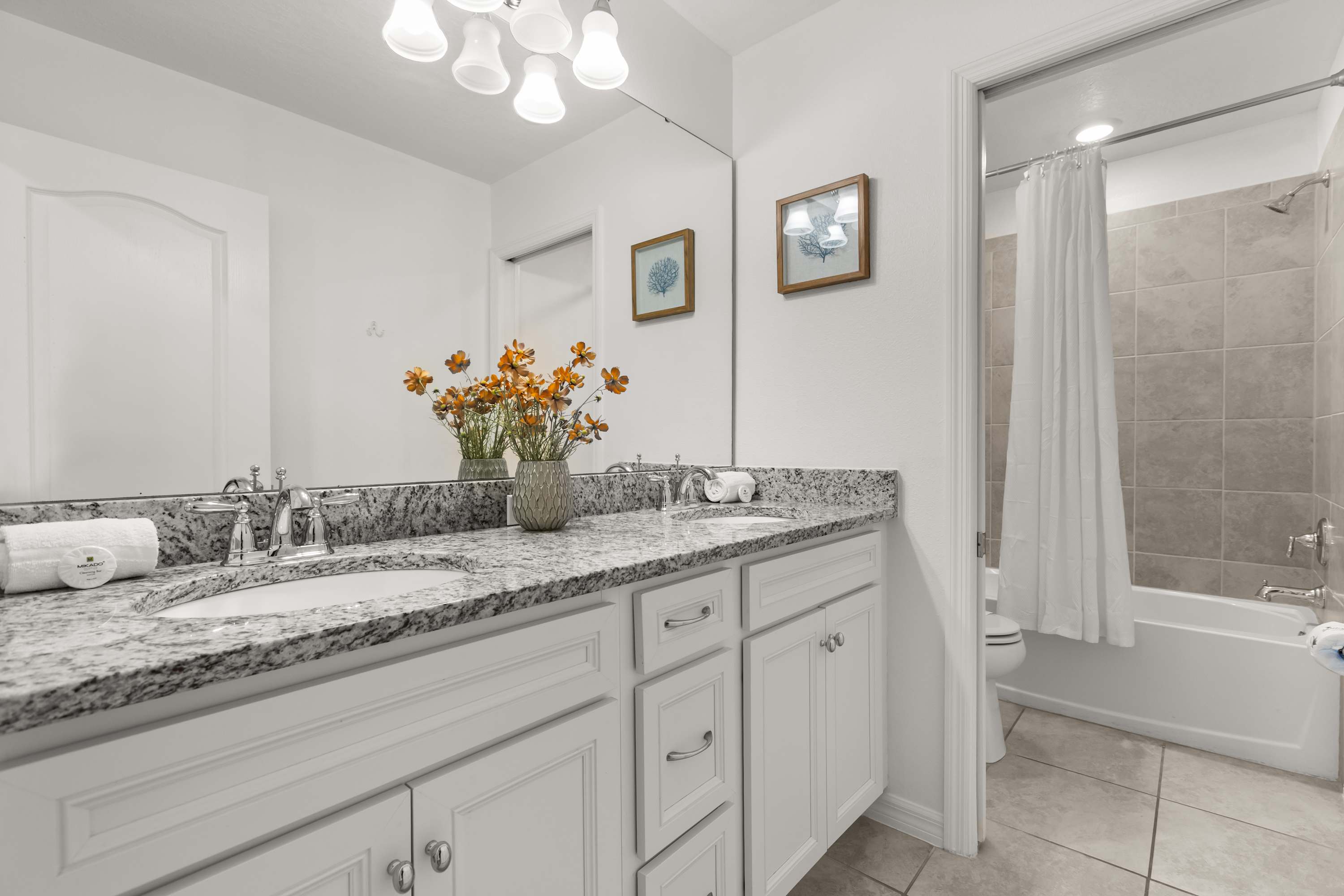 Full bathroom with double basin and combined bathtub and shower