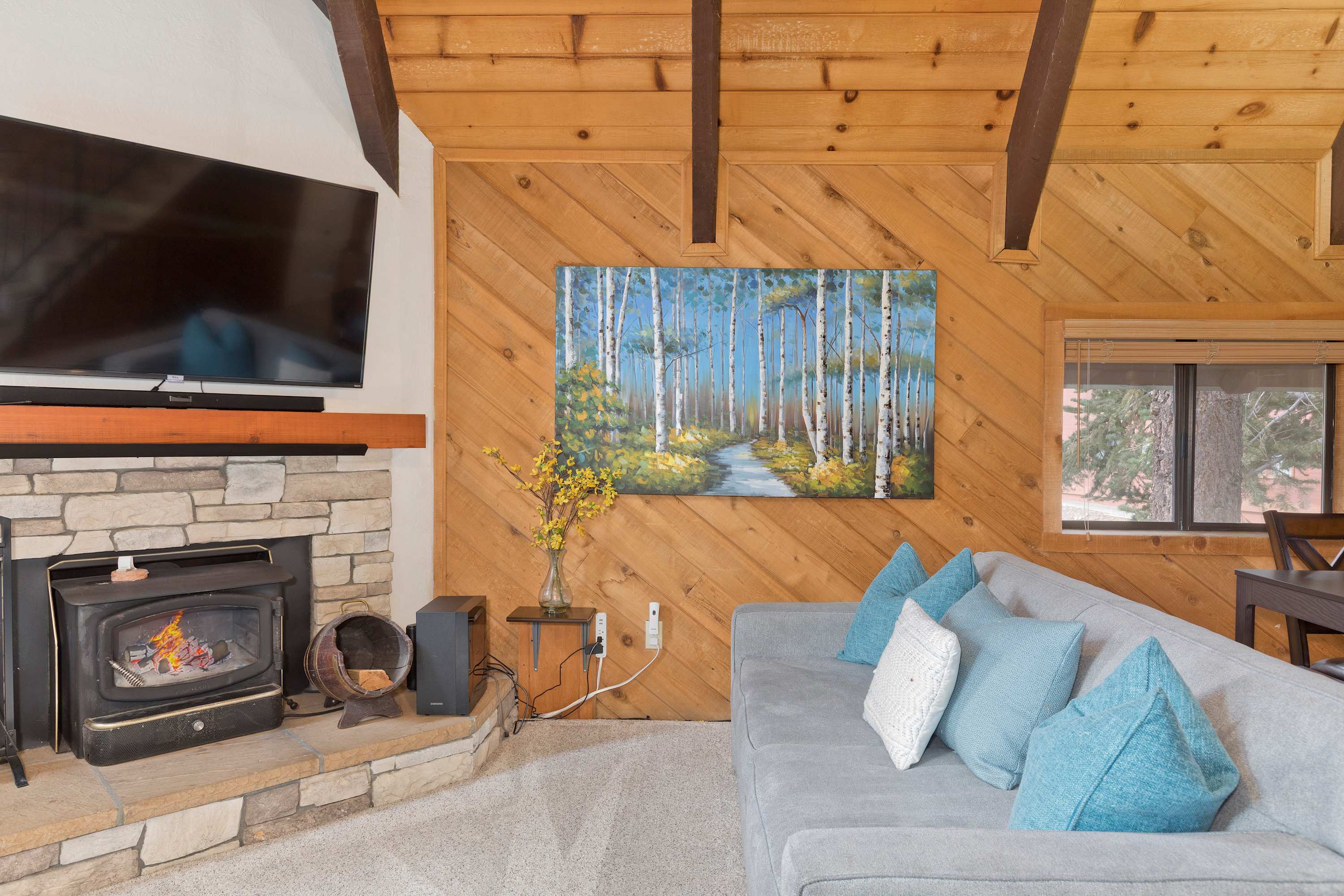 Cozy cabin living: fireplace, big TV, comfy seating. Deck access!