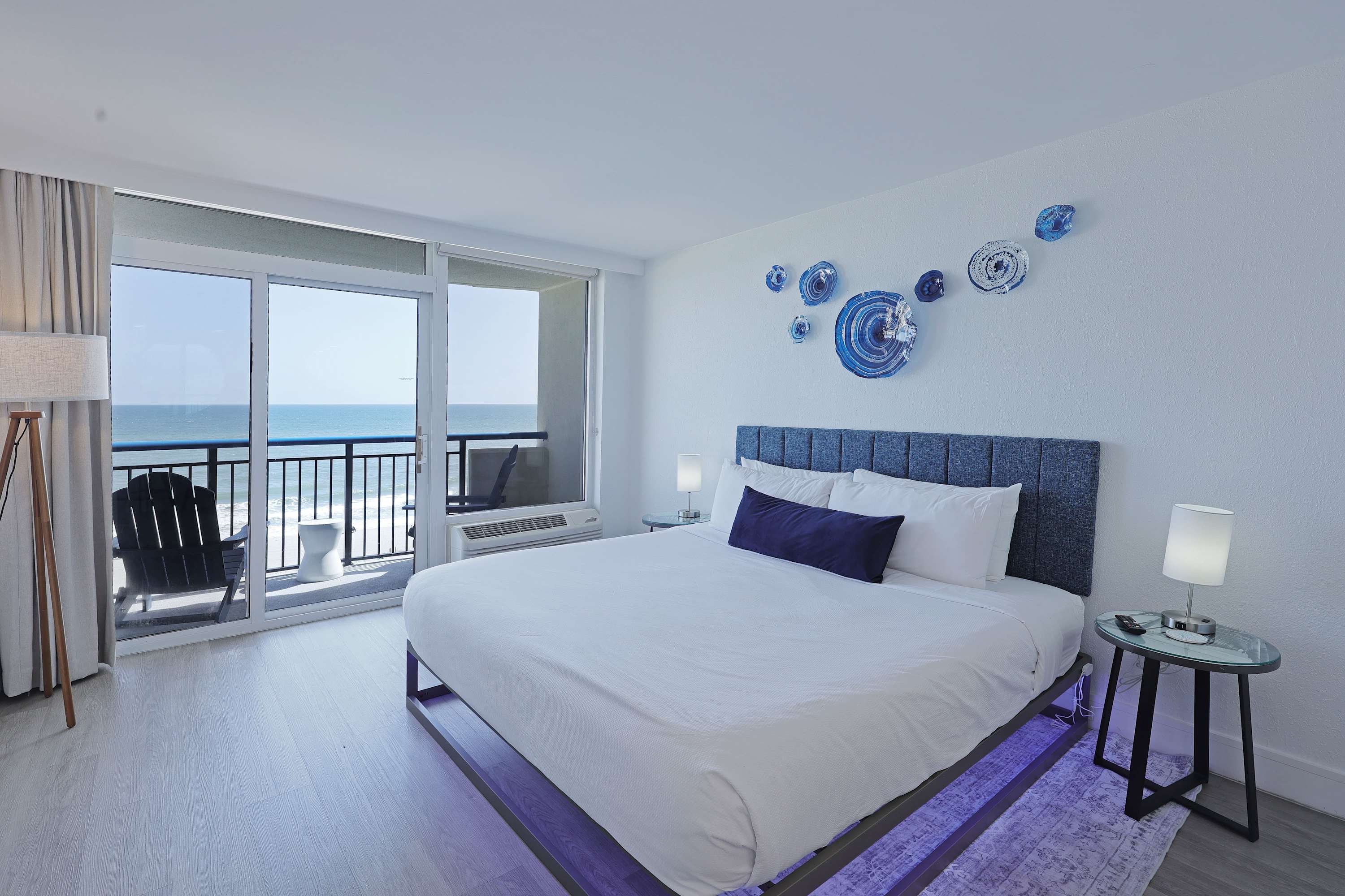 Wake up to stunning ocean views from this bright and modern bedroom, featuring a plush king bed, soft linens, and direct balcony access for the perfect start to your beach day.