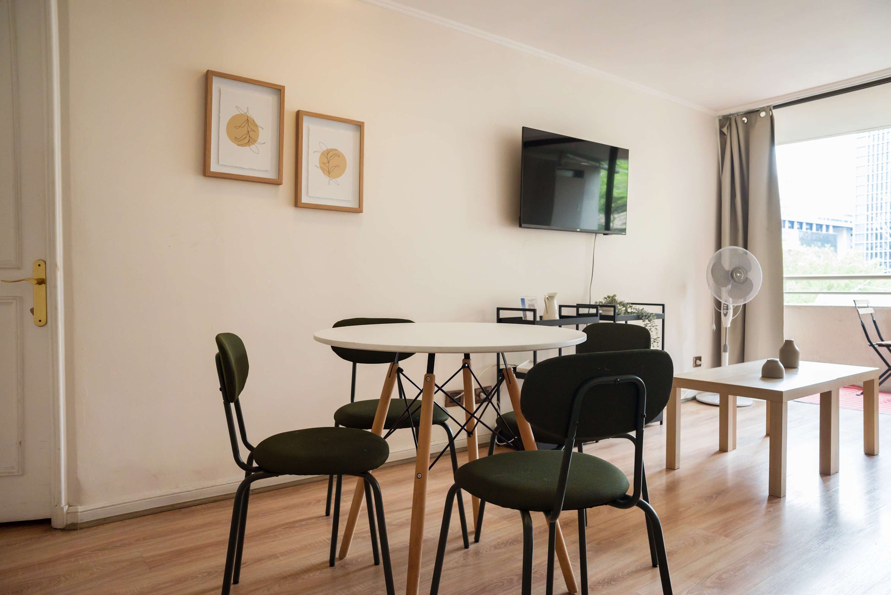 Cozy living area with a balcony view, perfect for relaxing or watching TV after exploring the city.