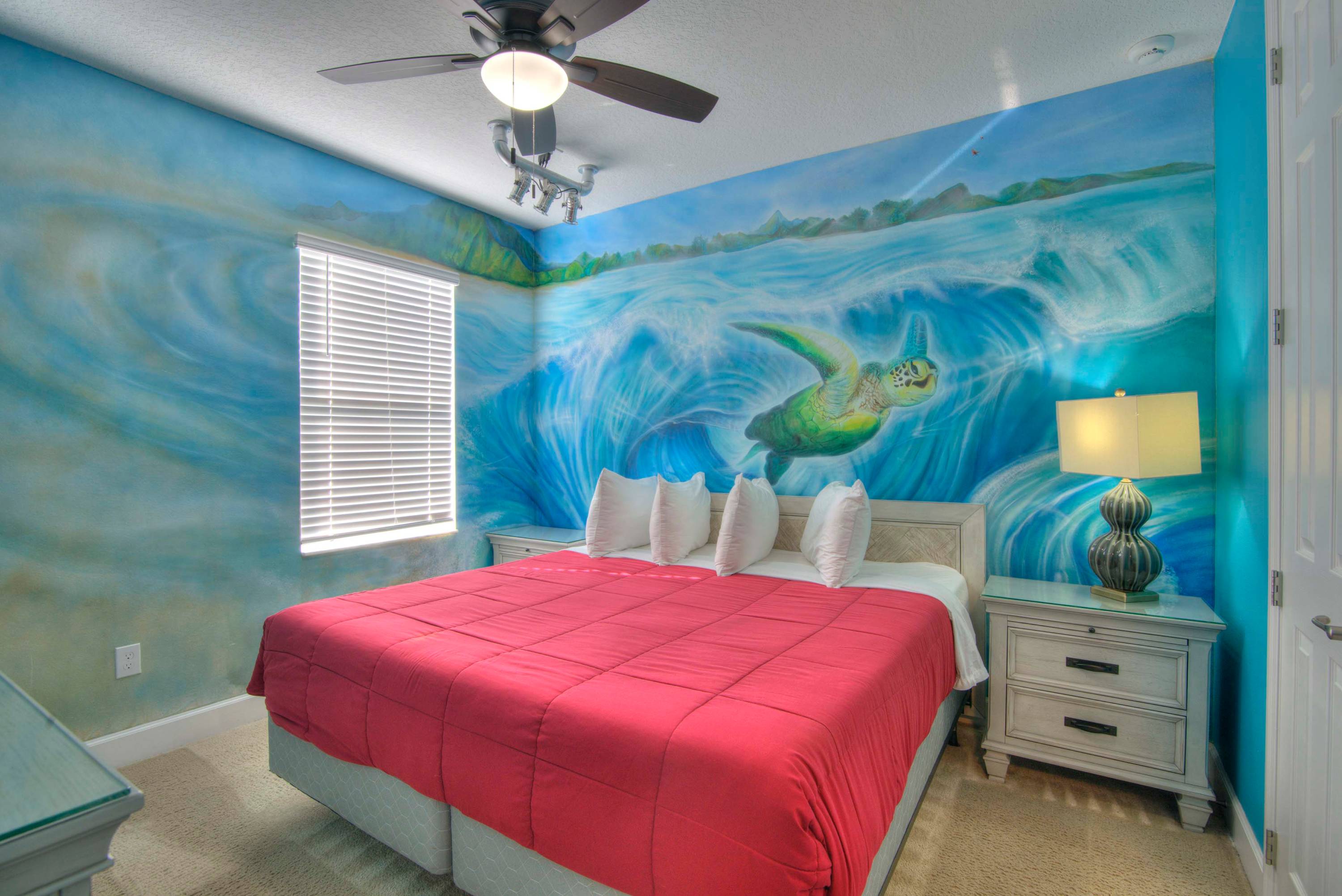 Dive into relaxation in this ocean-themed bedroom, complete with a stunning mural and cozy bedding.