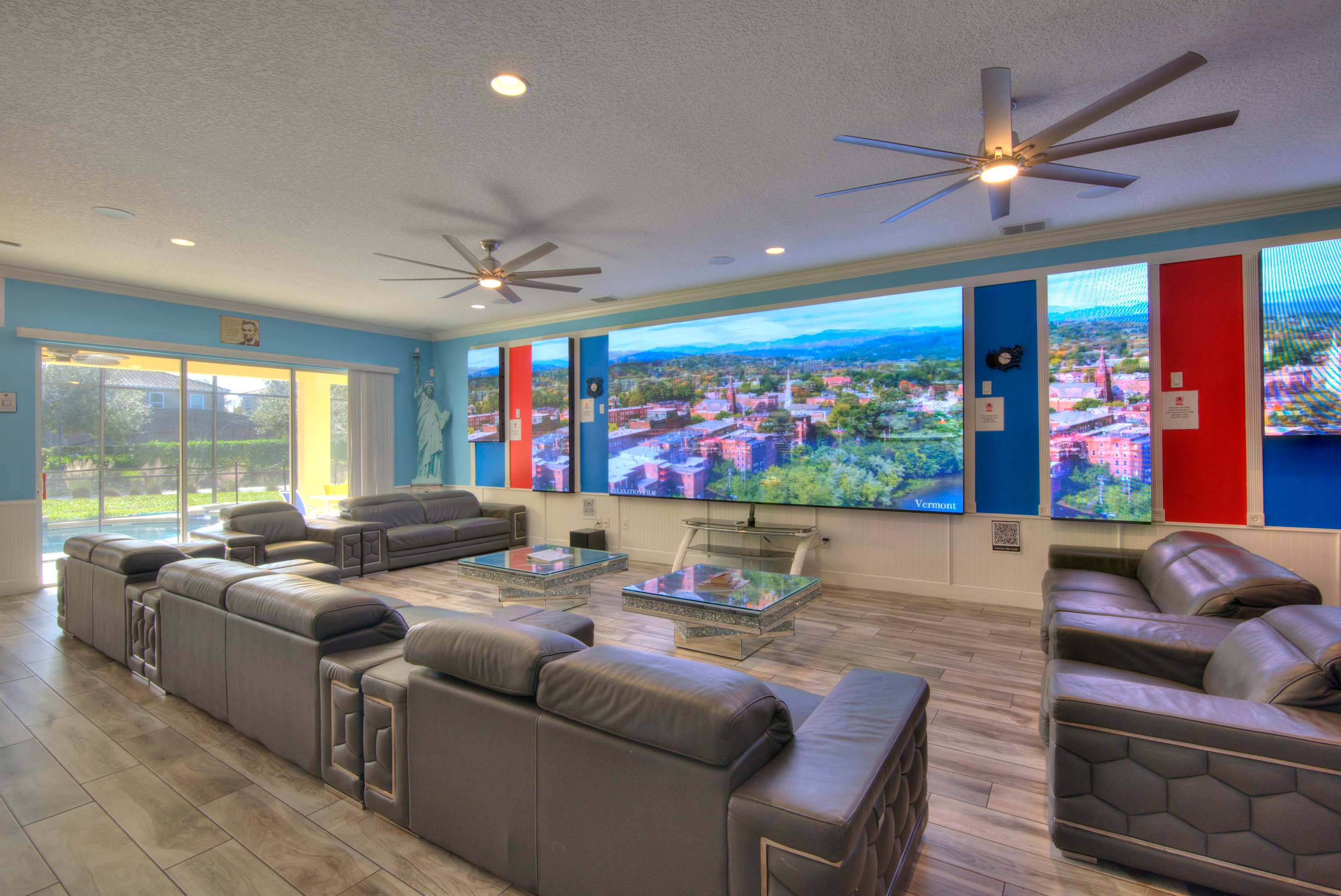 Experience ultimate relaxation in this expansive living room with a massive screen and cozy seating, perfect for gatherings.