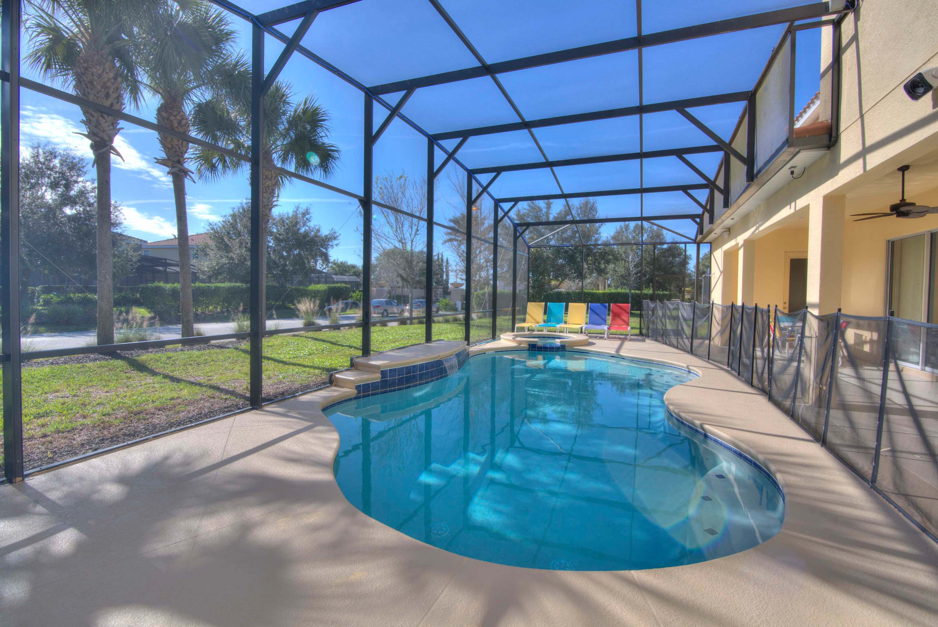 Relax in your private screened-in pool oasis, complete with colorful loungers and lush views.