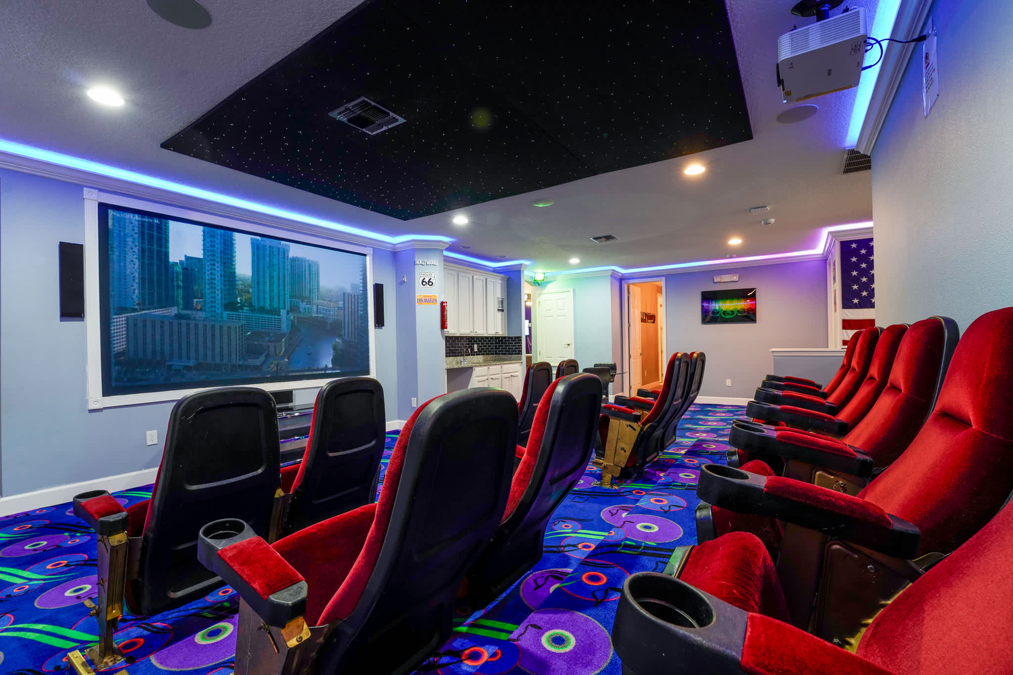 Enjoy a cinematic experience in your private home theater with plush seating, vibrant decor, and immersive lighting.