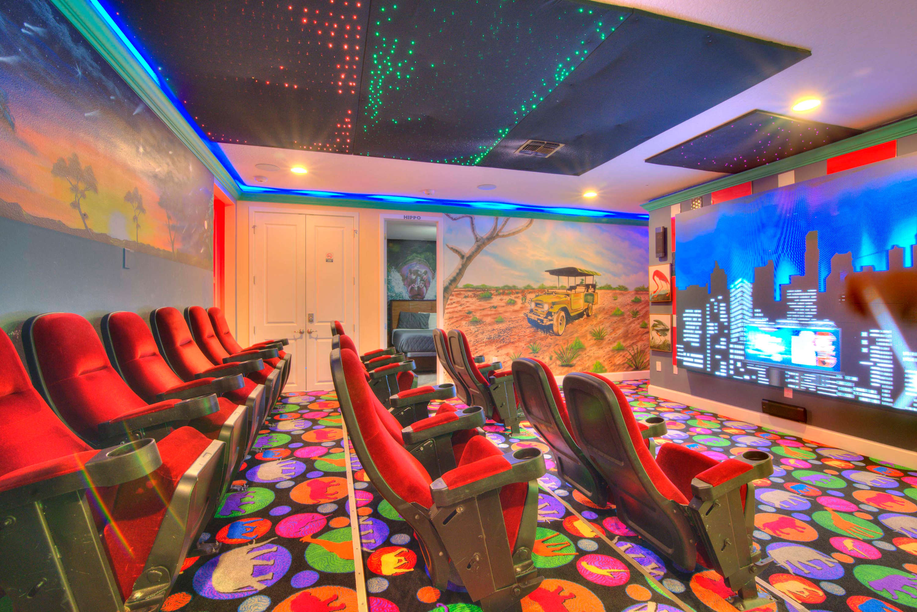 Enjoy a cinematic experience in your private theater with plush seating and vibrant decor, perfect for unforgettable movie nights.