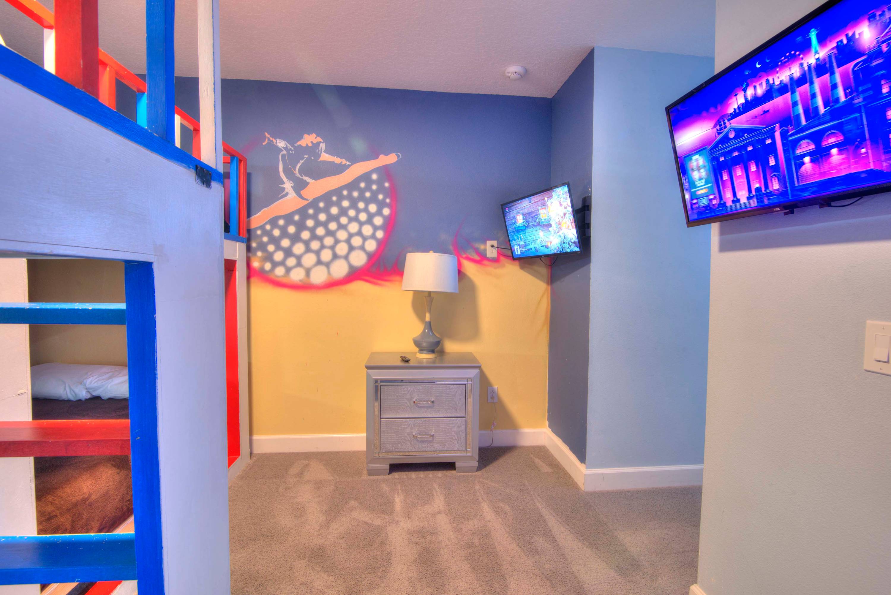 Vibrant theme room with bunk beds and dual TVs, perfect for kids or teens to enjoy their own space.