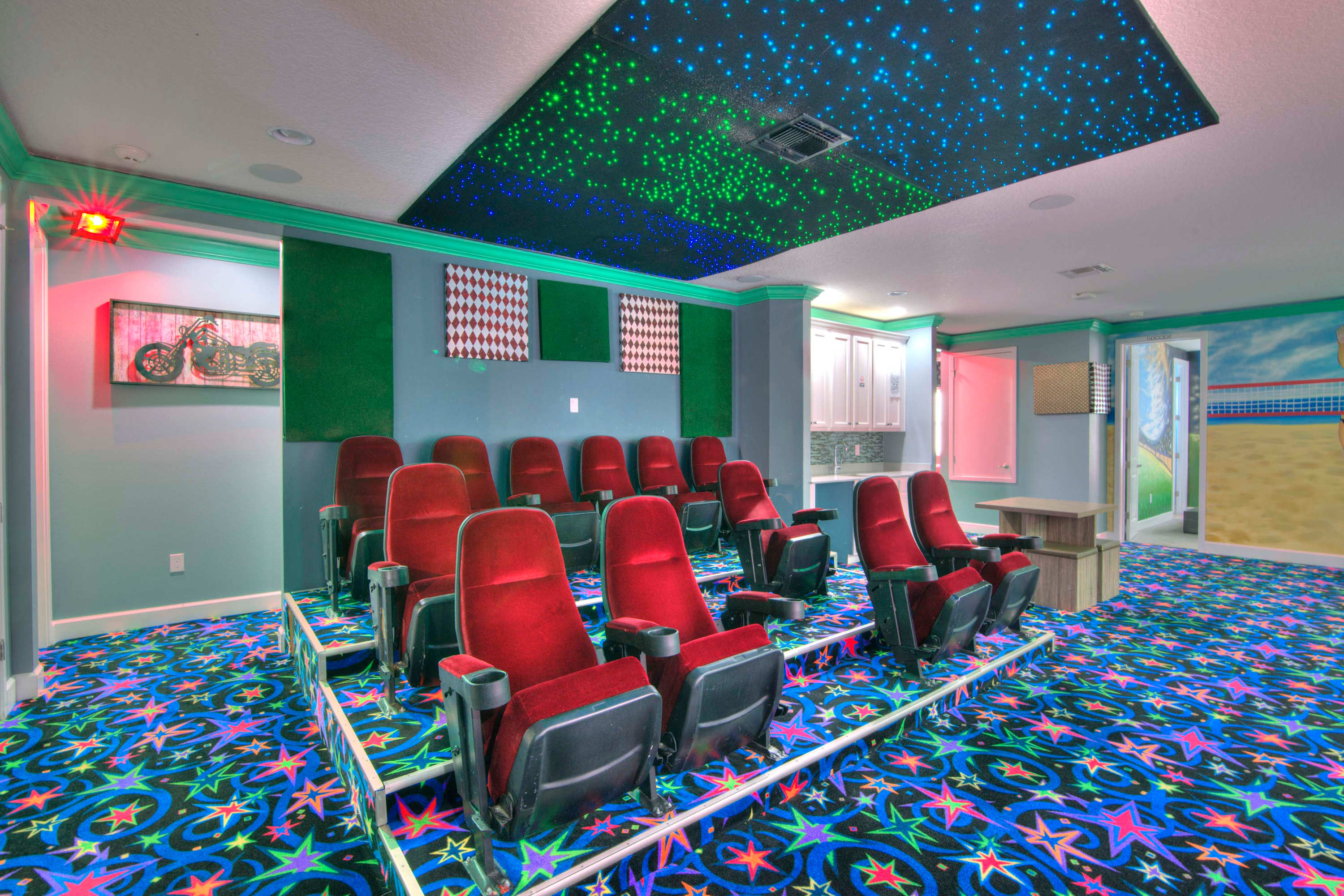 Enjoy a private movie night in this vibrant home theater with starry ceiling and cozy seating.