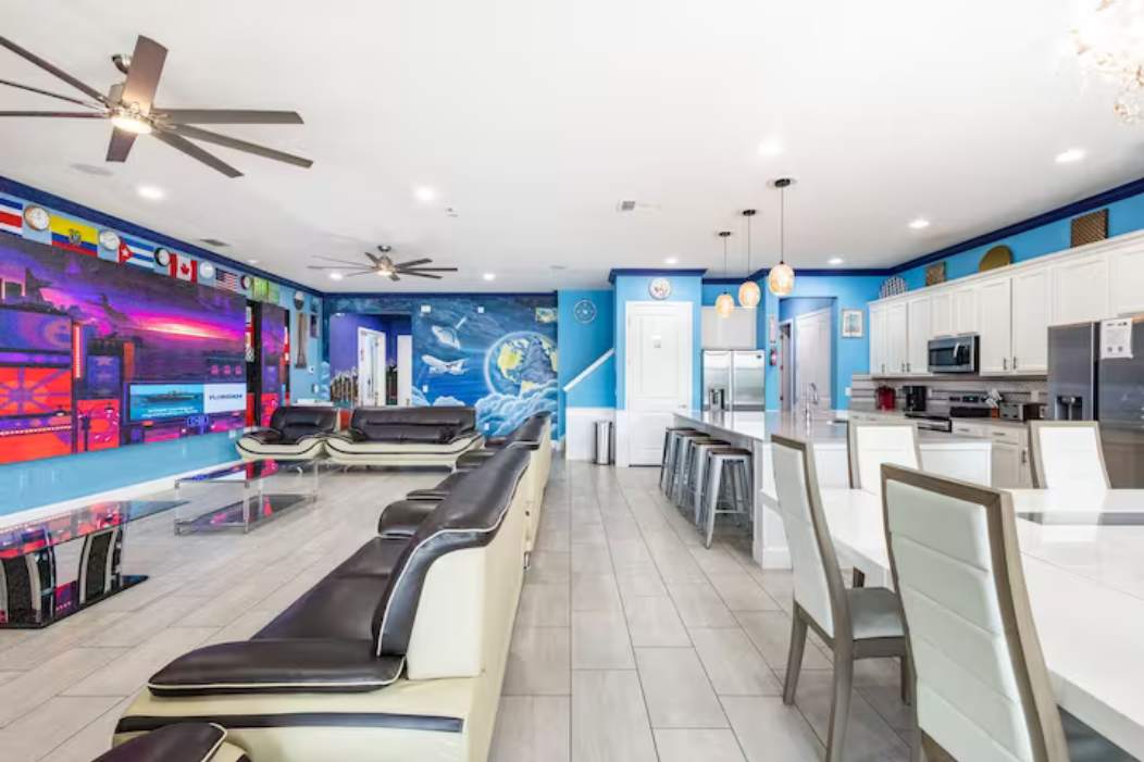 Experience luxury in this expansive living area with vibrant murals and a modern kitchen, perfect for entertaining large groups.