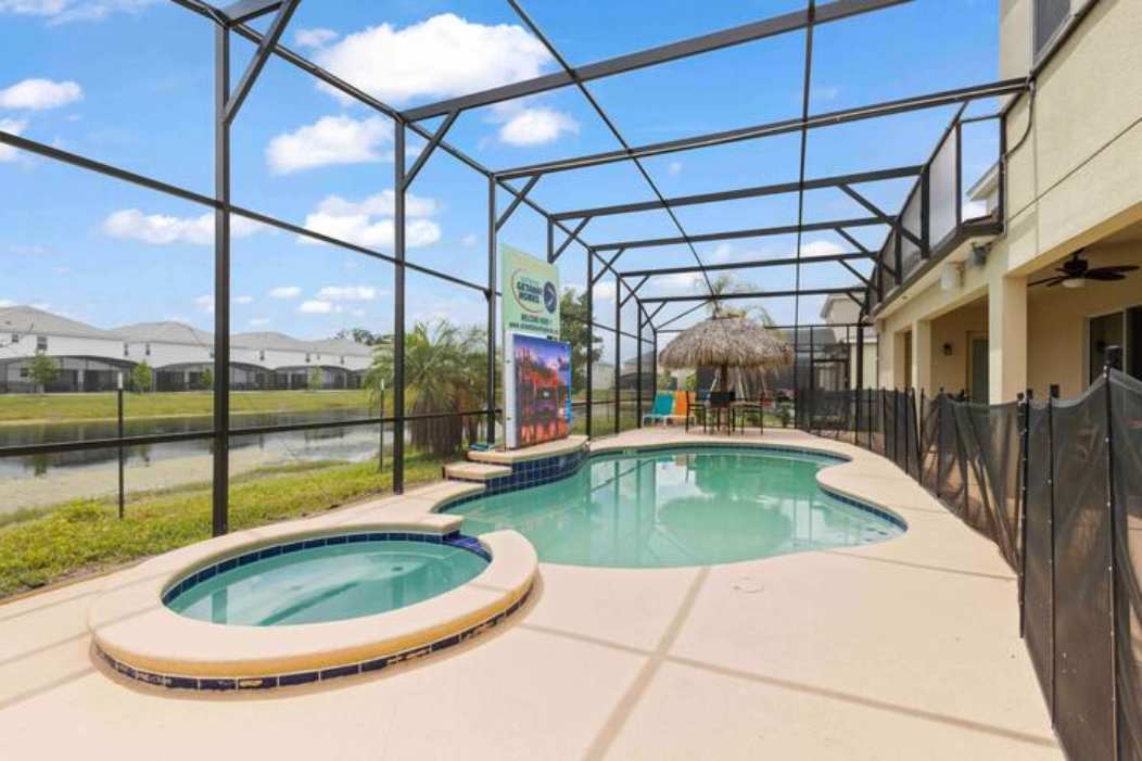 Relax in your private screened-in pool oasis with a hot tub and tiki-style seating, perfect for unwinding after a day of adventure.