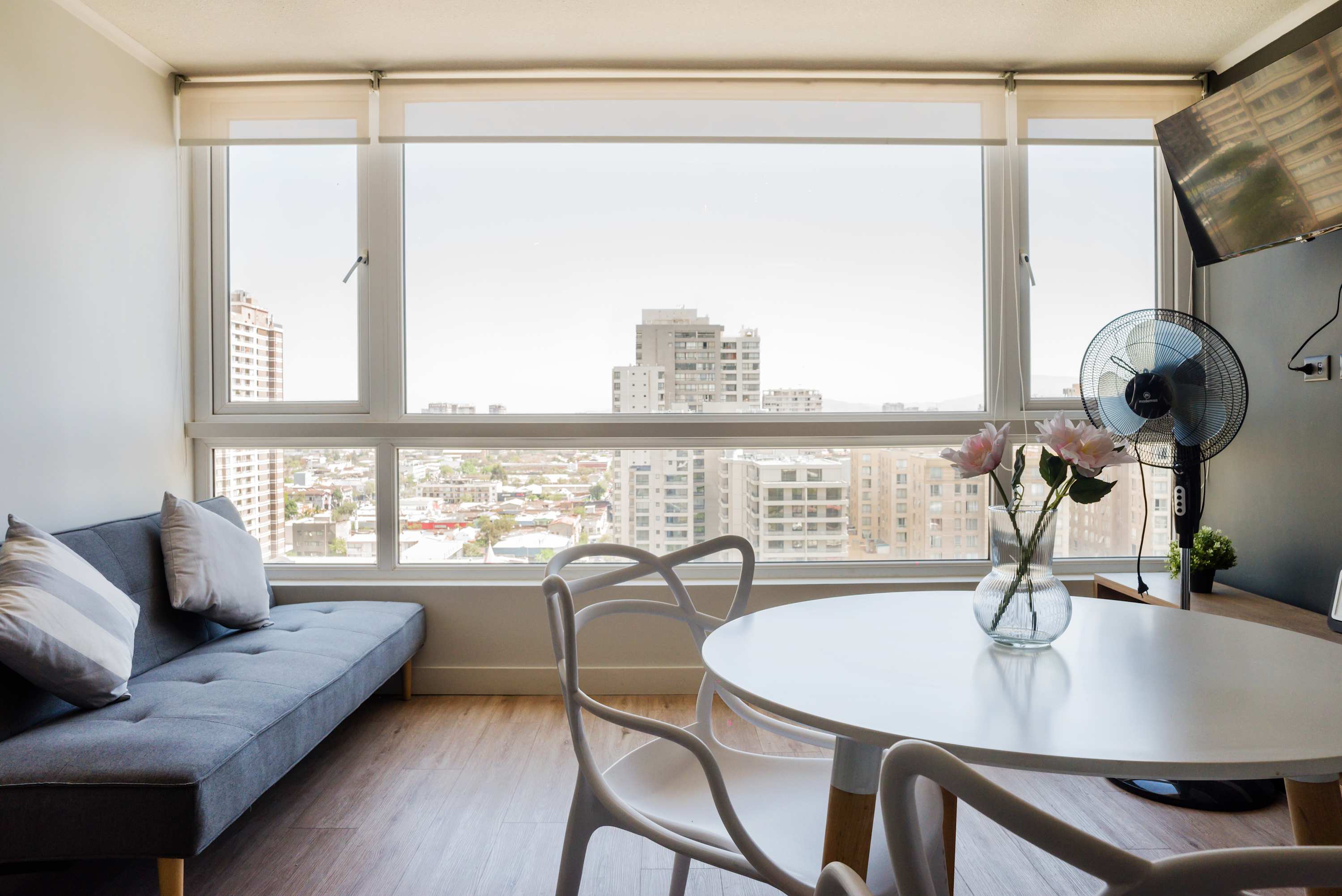 Relax in a bright living space with stunning city views, modern decor, and cozy seating.