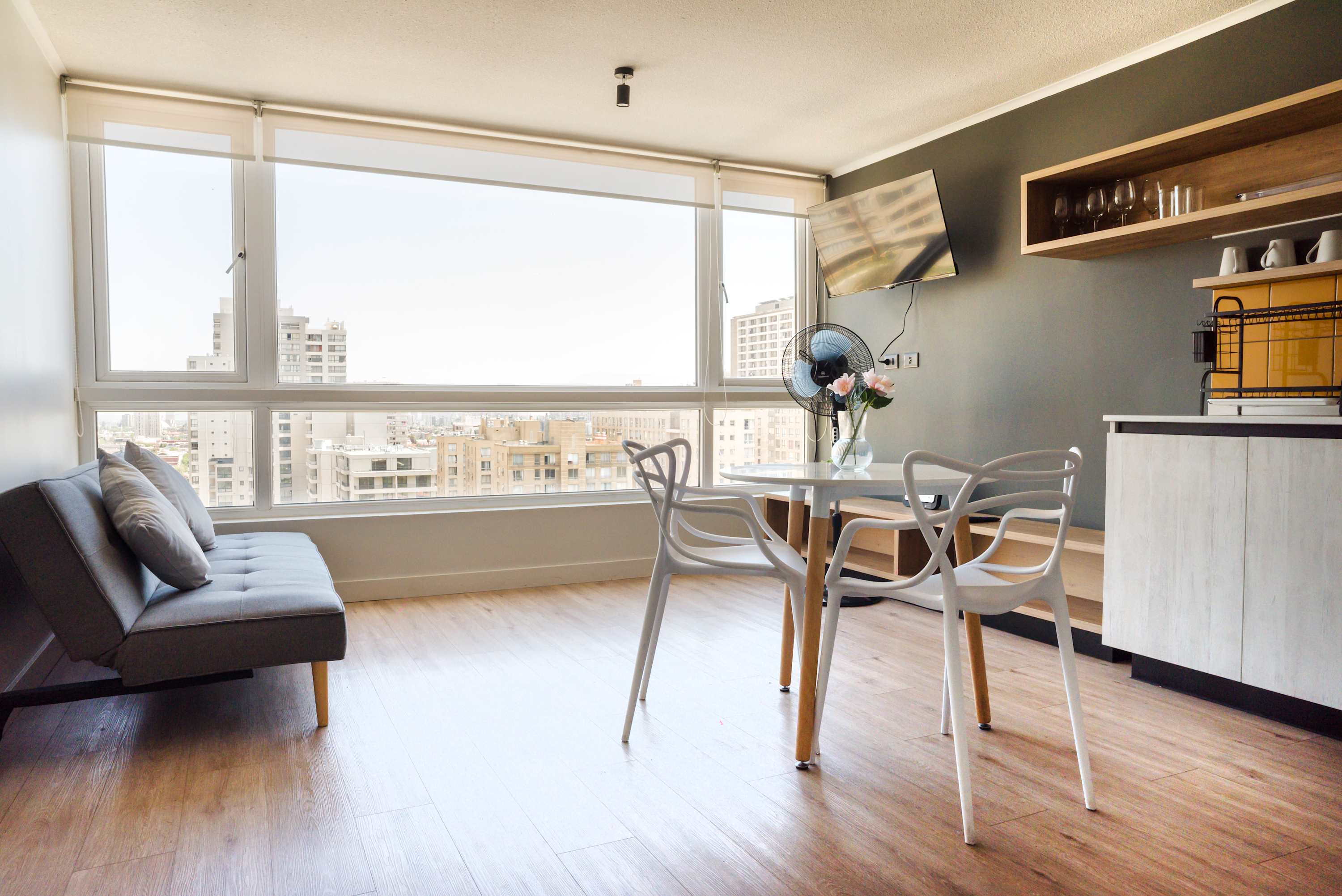 Relax in this bright studio with panoramic city views, a cozy seating area, and a sleek dining space.