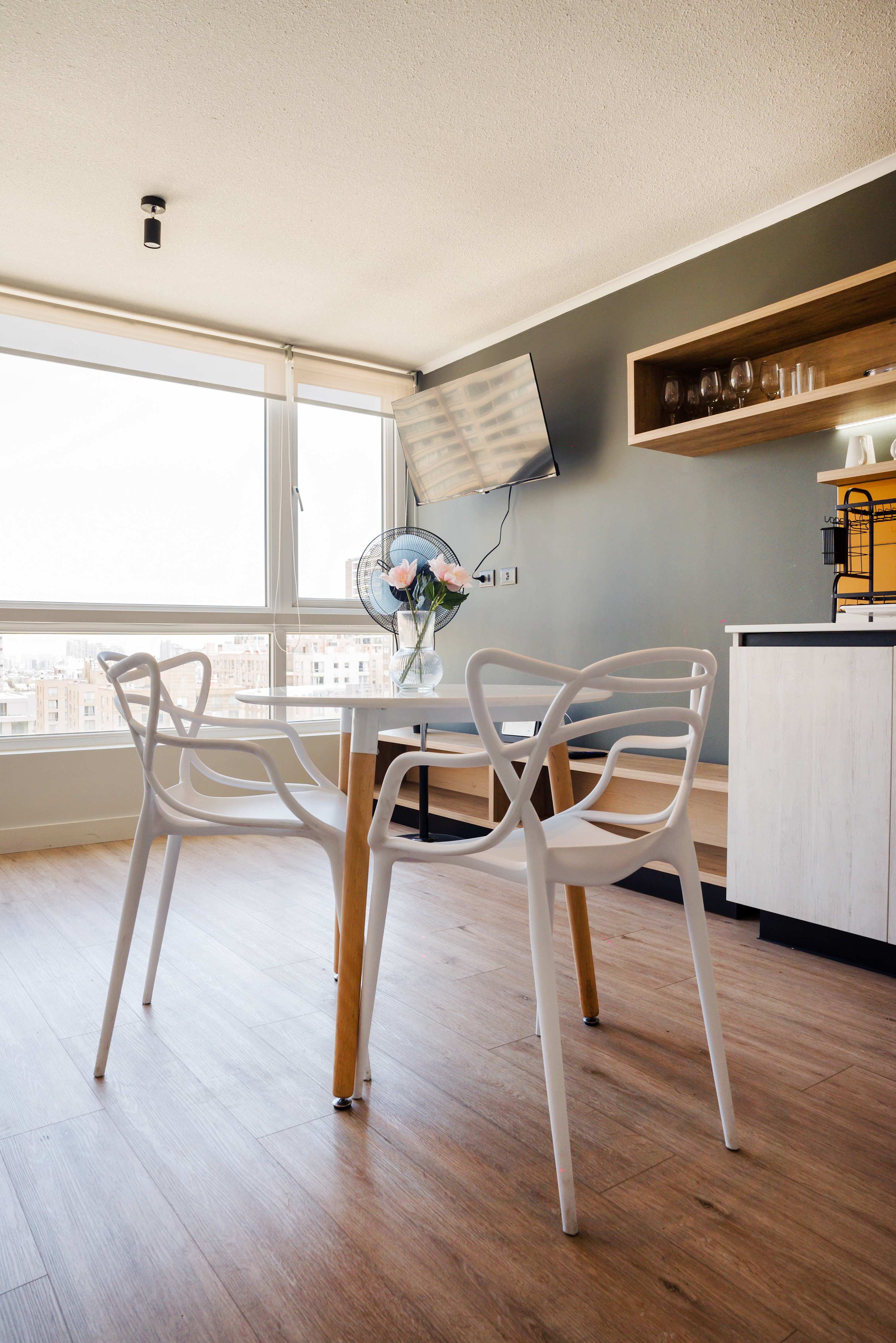 Enjoy meals with stunning city views in this modern dining space, complete with a wall-mounted TV and stylish decor.