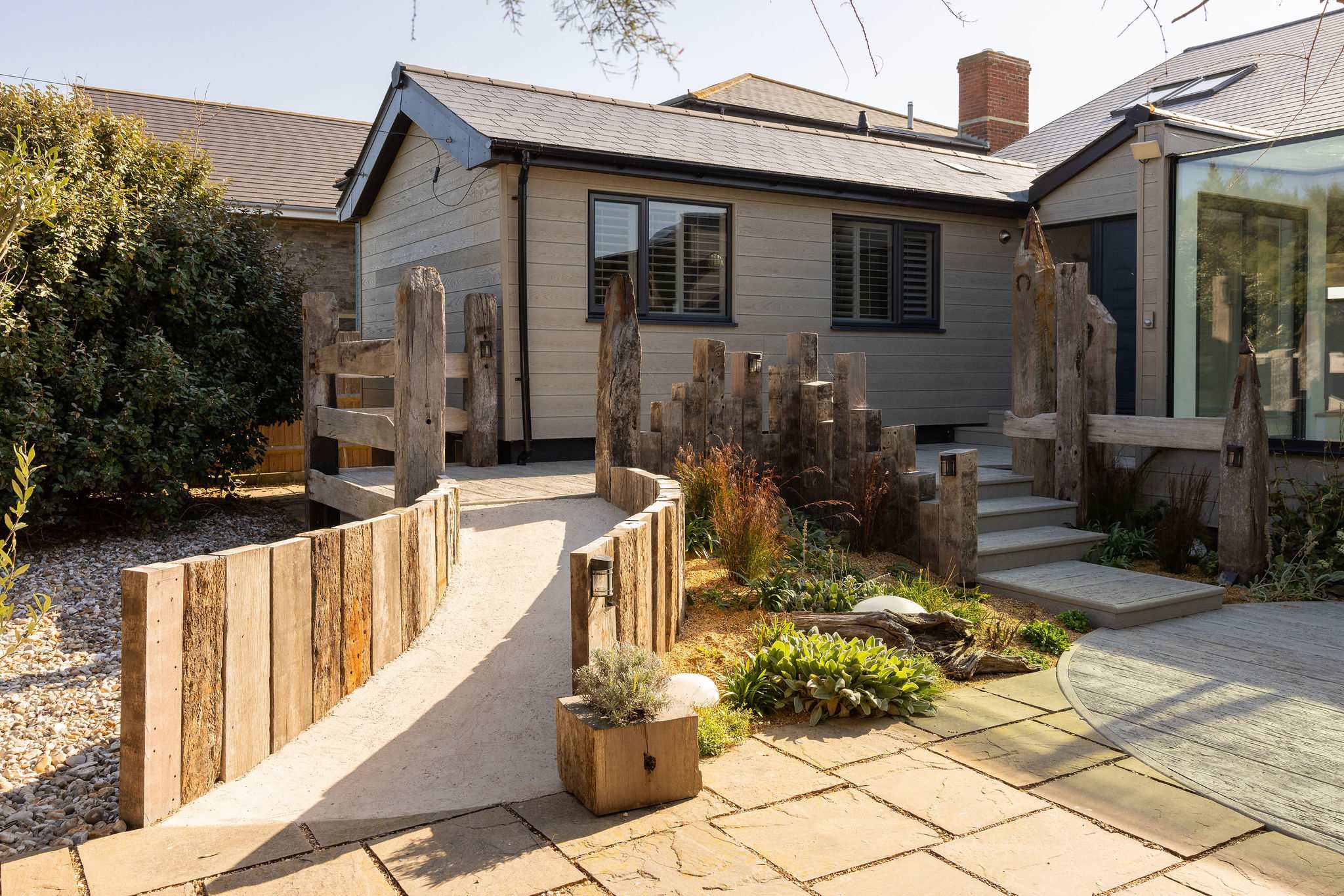 Landscaped front entrance with sleepers and planters.