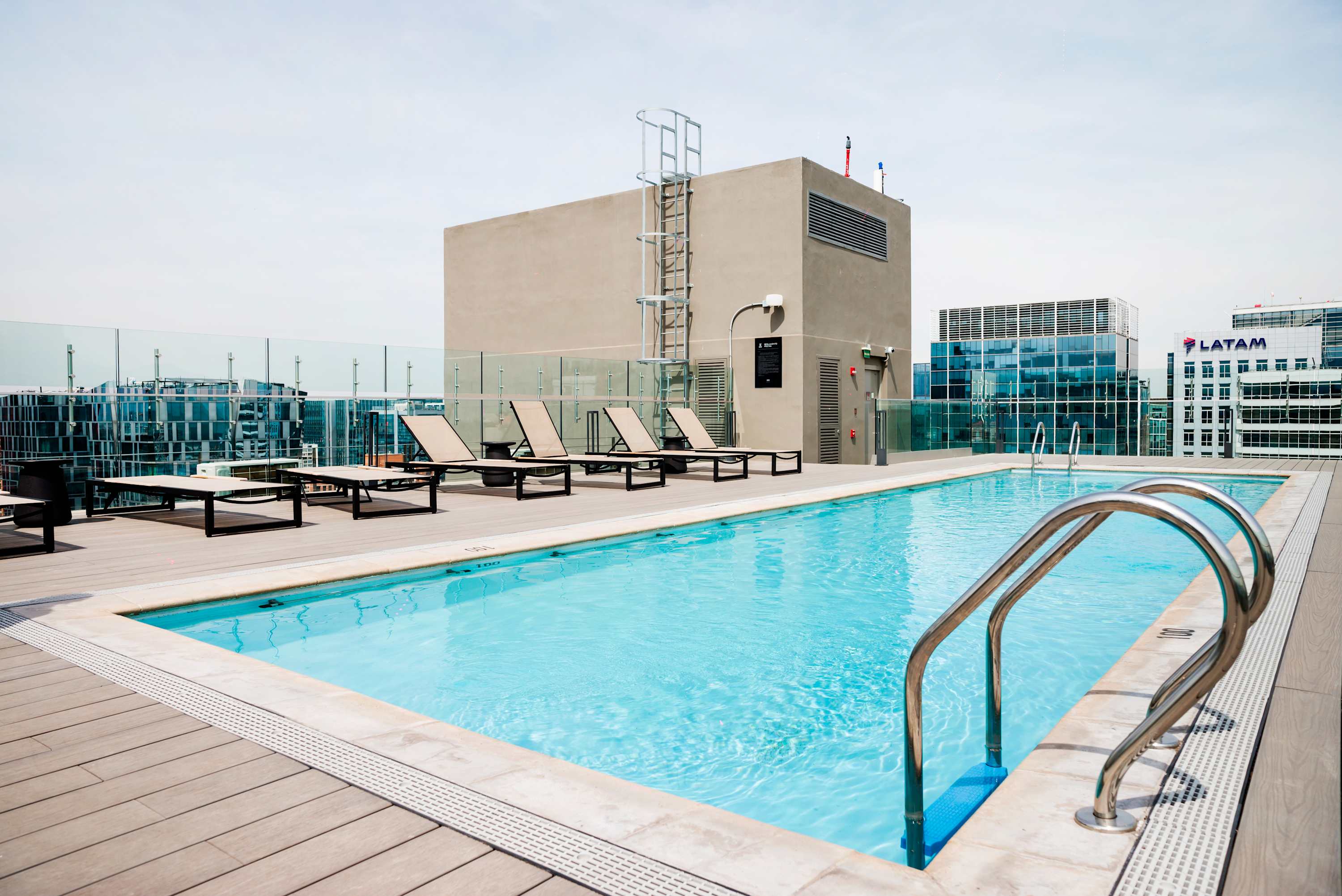 Enjoy stunning city views from this rooftop pool oasis, perfect for relaxation and sunbathing.