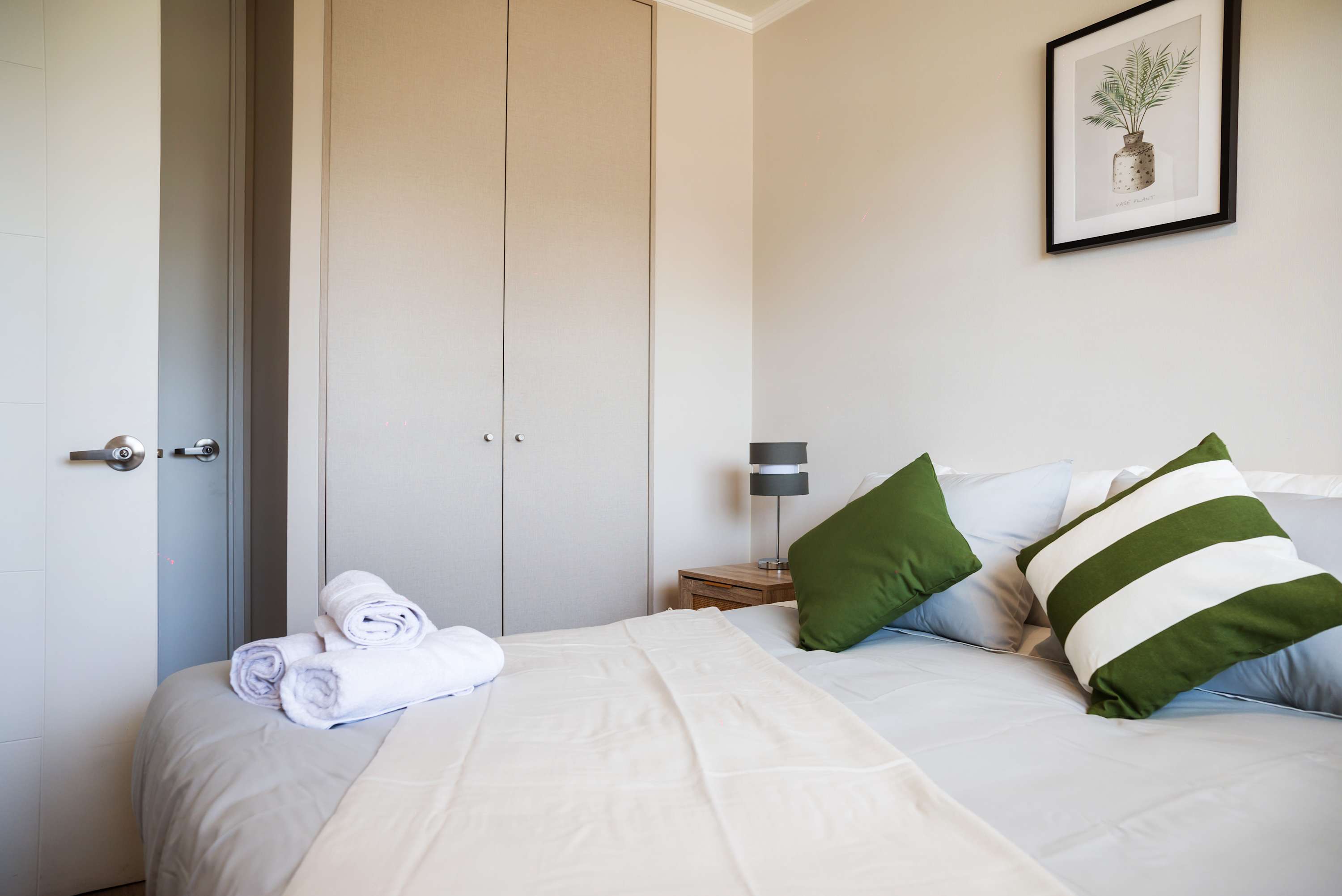 Relax in this serene bedroom with plush bedding and stylish decor, perfect for a restful stay.