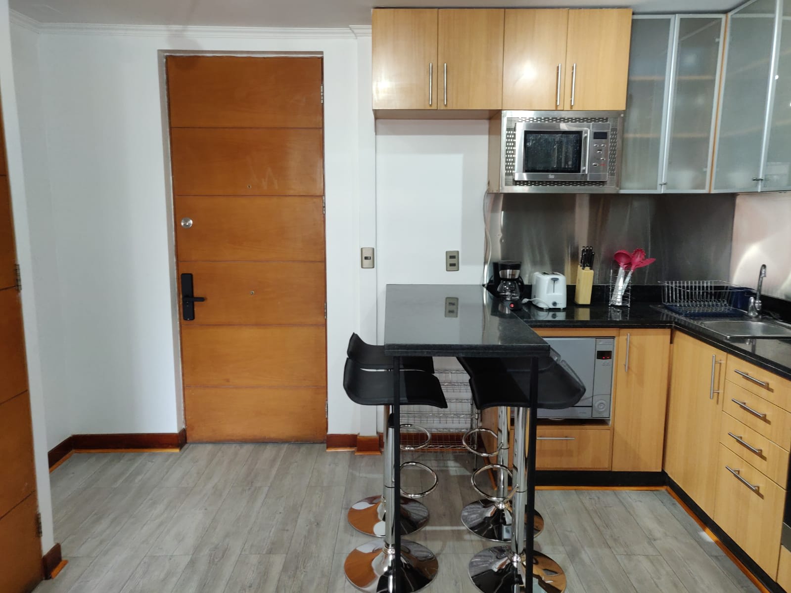 Sleek kitchen with modern appliances and cozy bar seating, ideal for a quick meal or coffee break.