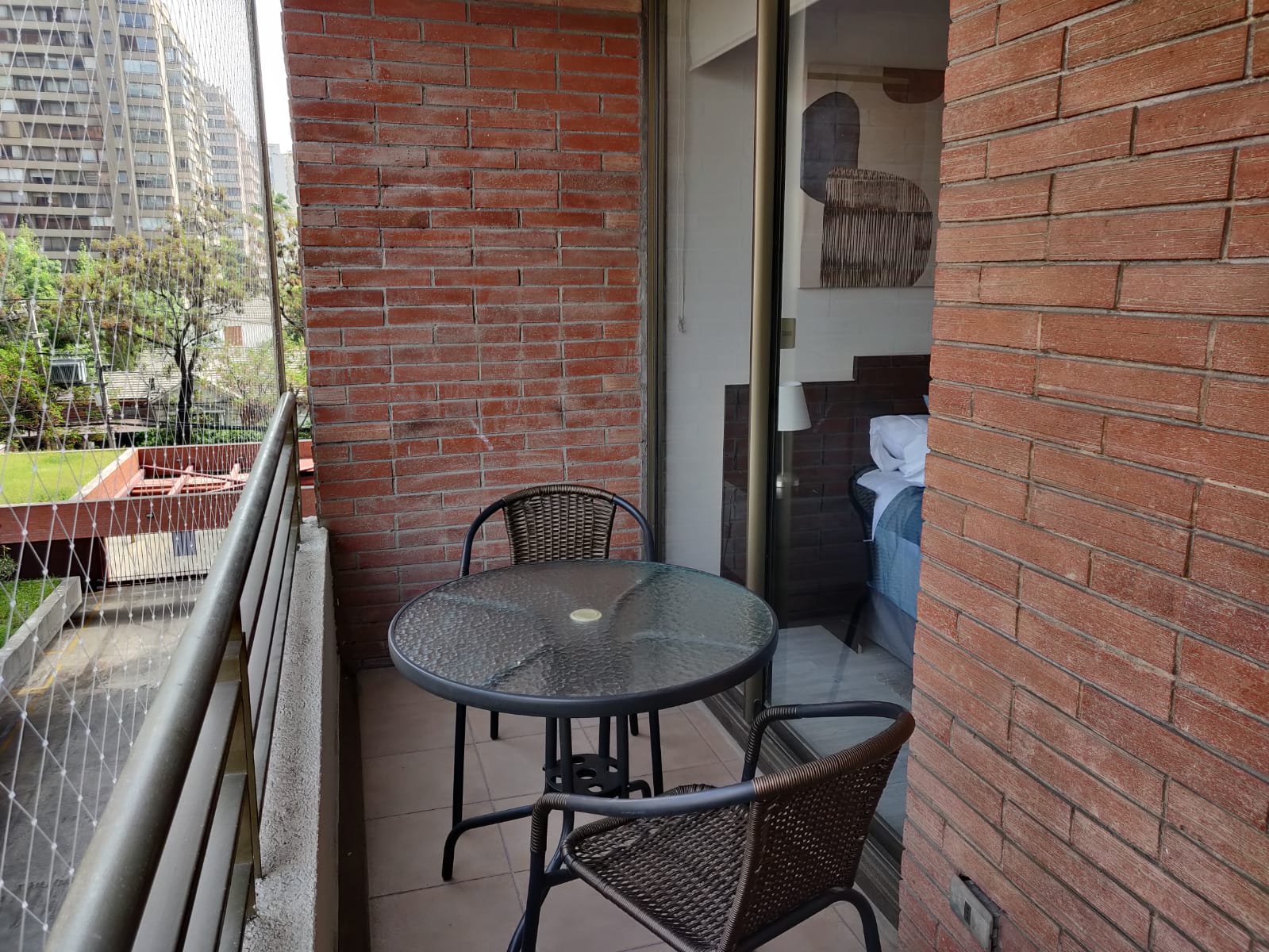 Charming private balcony with seating for two, ideal for sipping coffee while enjoying city views.