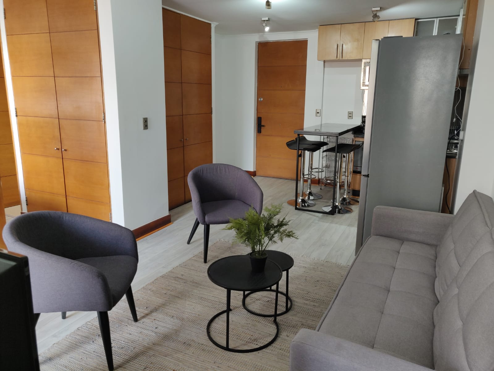 Relax in a cozy living area with modern seating and a sleek kitchen bar, perfect for unwinding or dining.