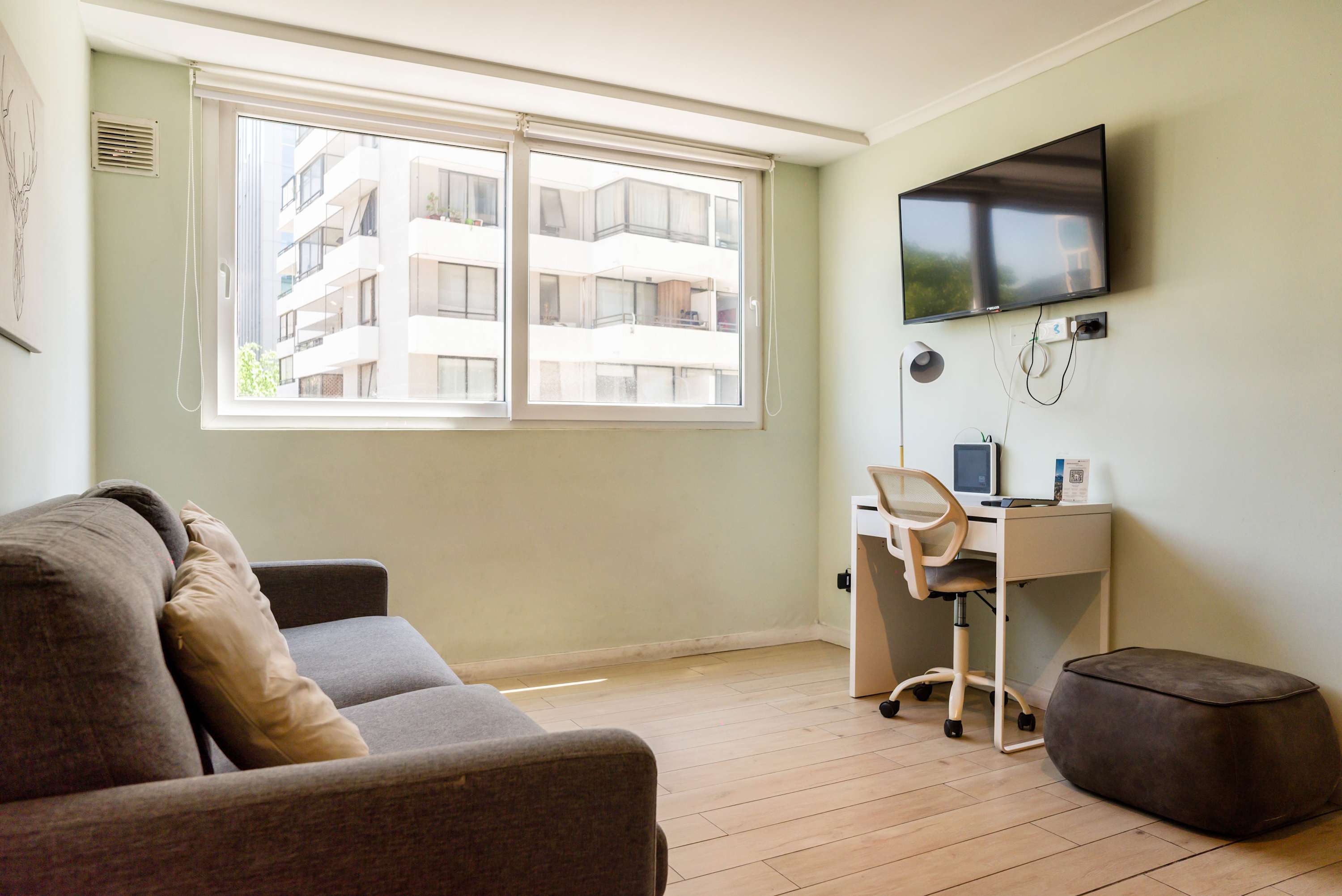 Bright and cozy living area with a comfy sofa and workspace, perfect for relaxation or remote work.