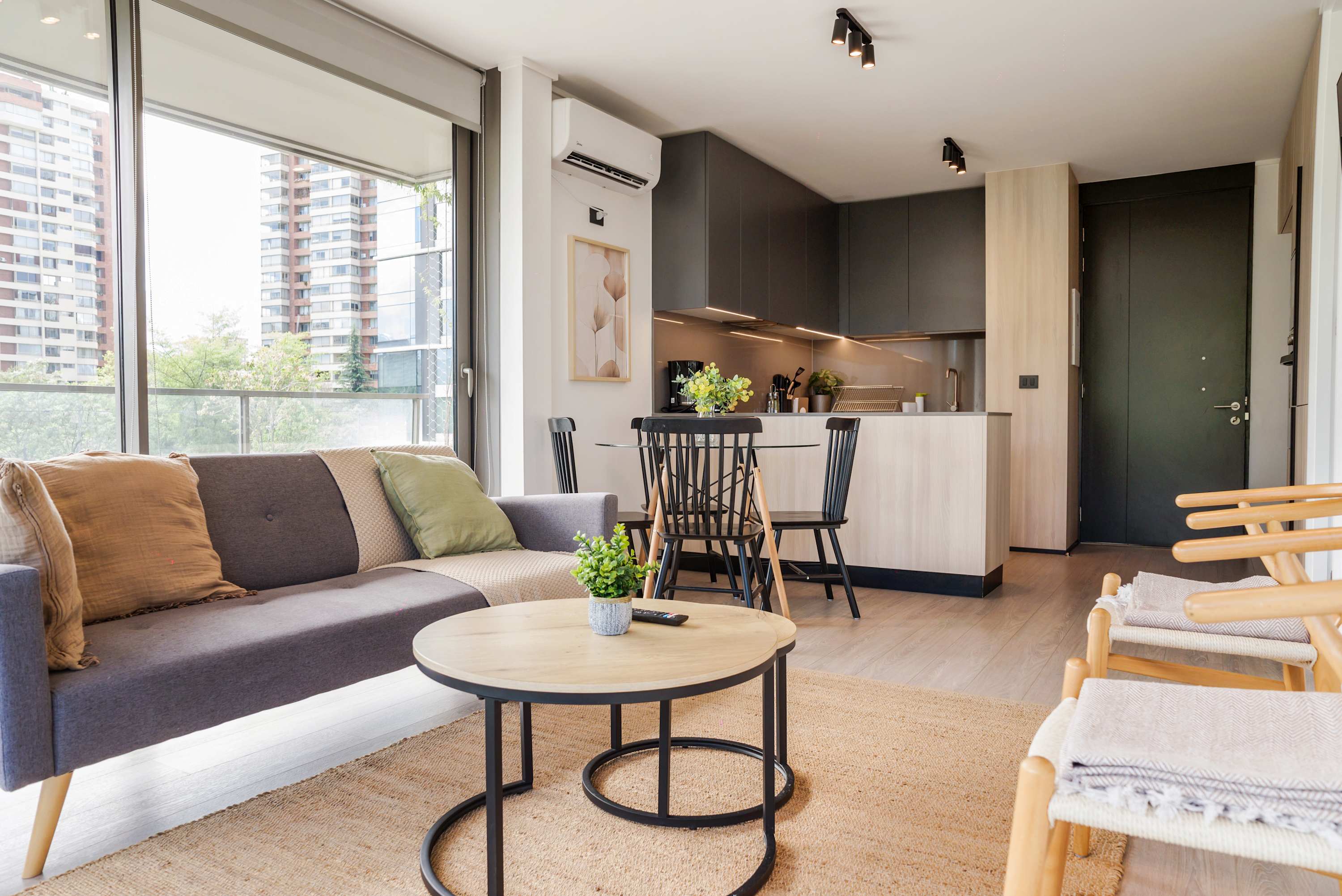 Bright and stylish living space with modern kitchen and cozy seating, perfect for relaxation and dining.