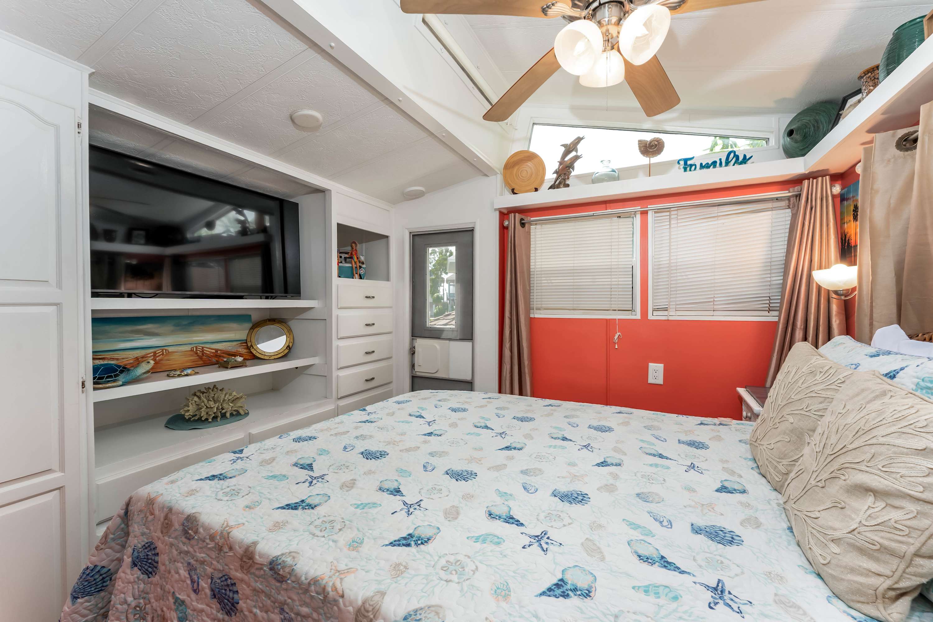 Queen Bedroom – Rest easy in a snug retreat with soft bedding, coastal décor, and warm lighting.