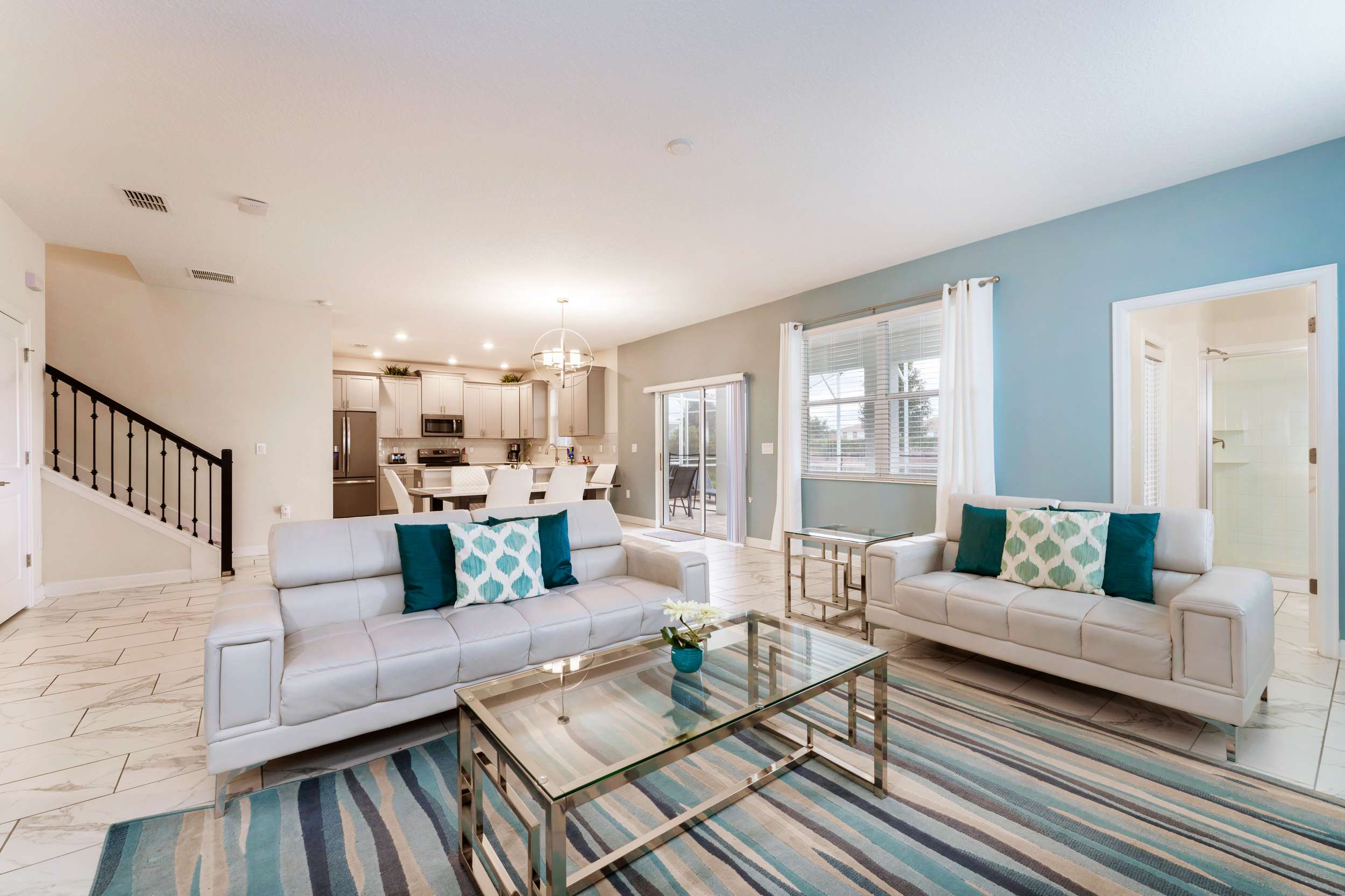 Elegant open-plan living area with modern decor and ample natural light, perfect for relaxing and entertaining.