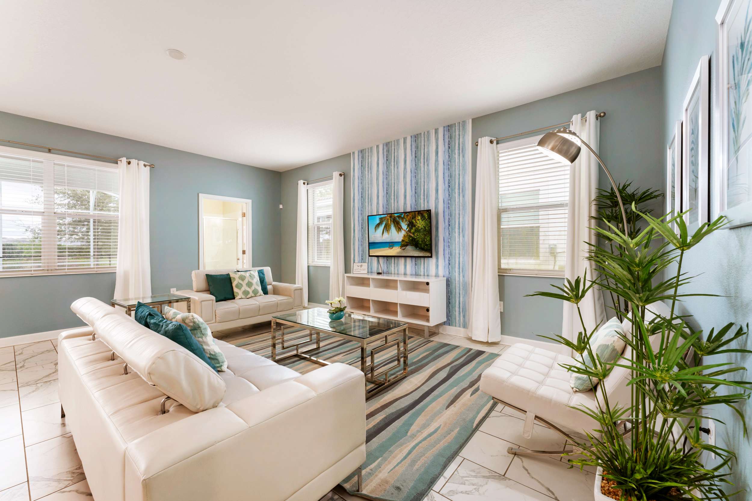 Relax in style in this modern living room with plush seating, a flat-screen TV, and abundant natural light.