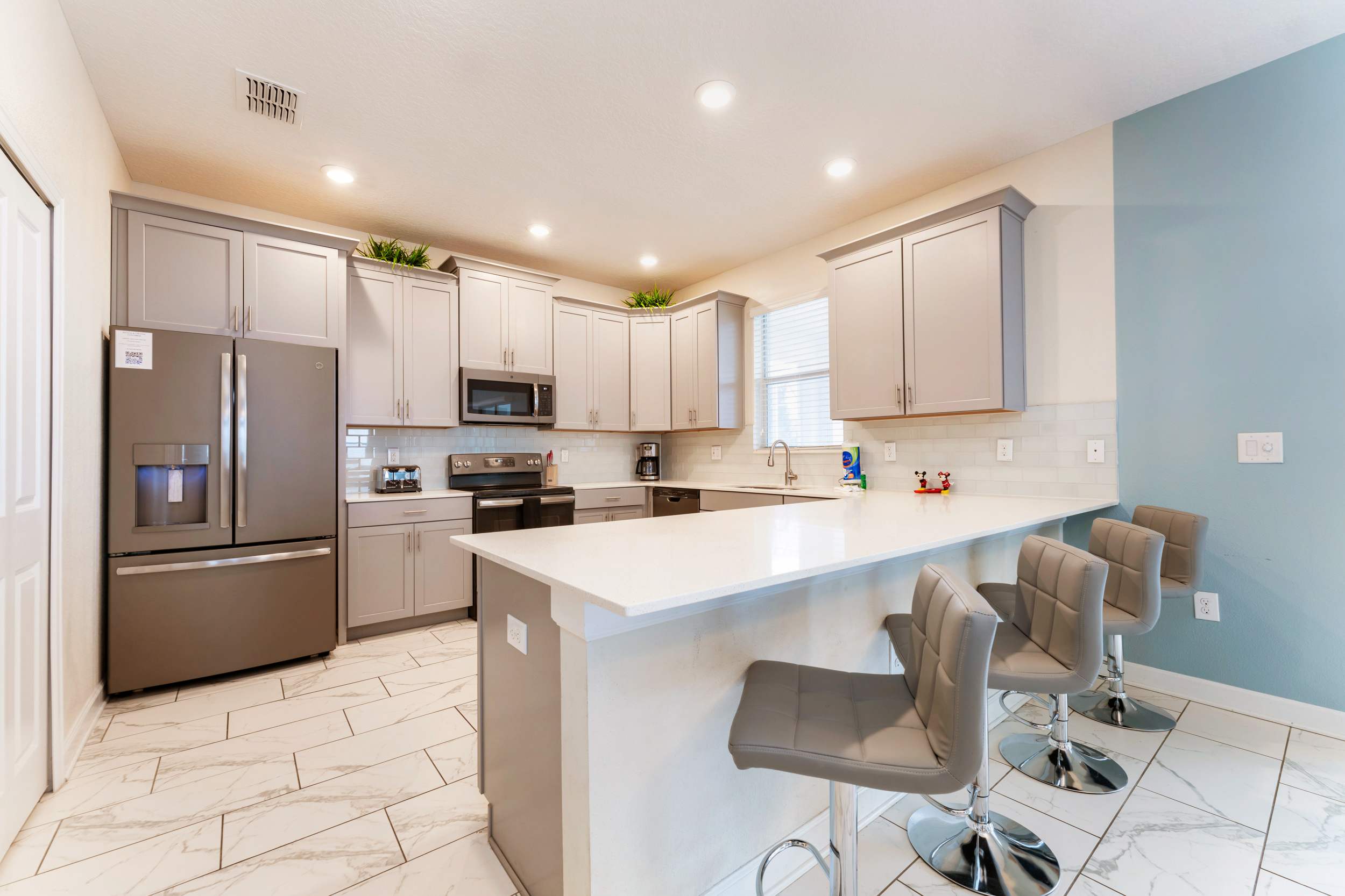 Spacious modern kitchen with sleek appliances and ample seating, perfect for family gatherings and culinary adventures.