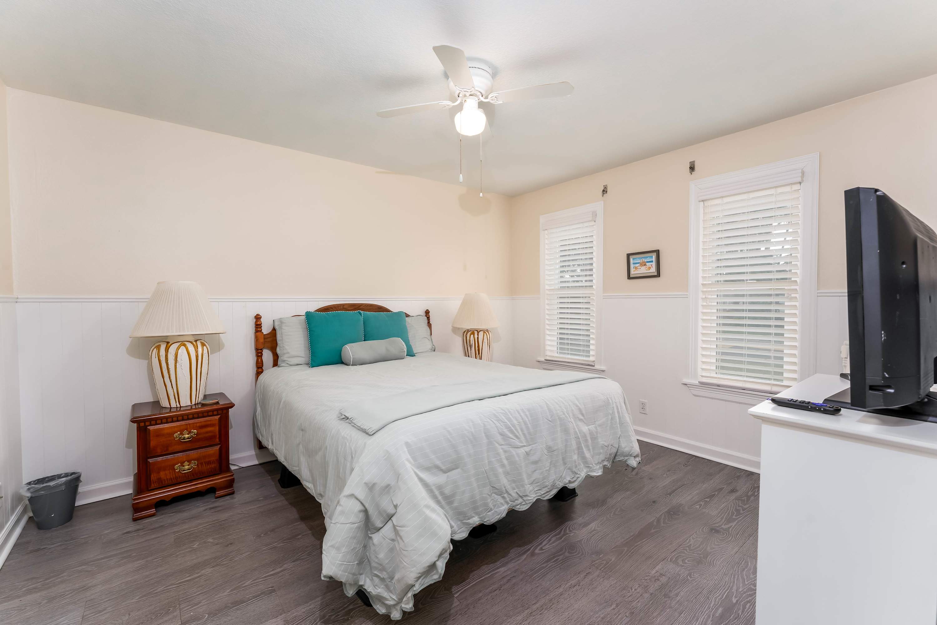 Queen Bedroom with TV — Comfortable queen bed and private access to the patio deck—perfect for morning views of the water.