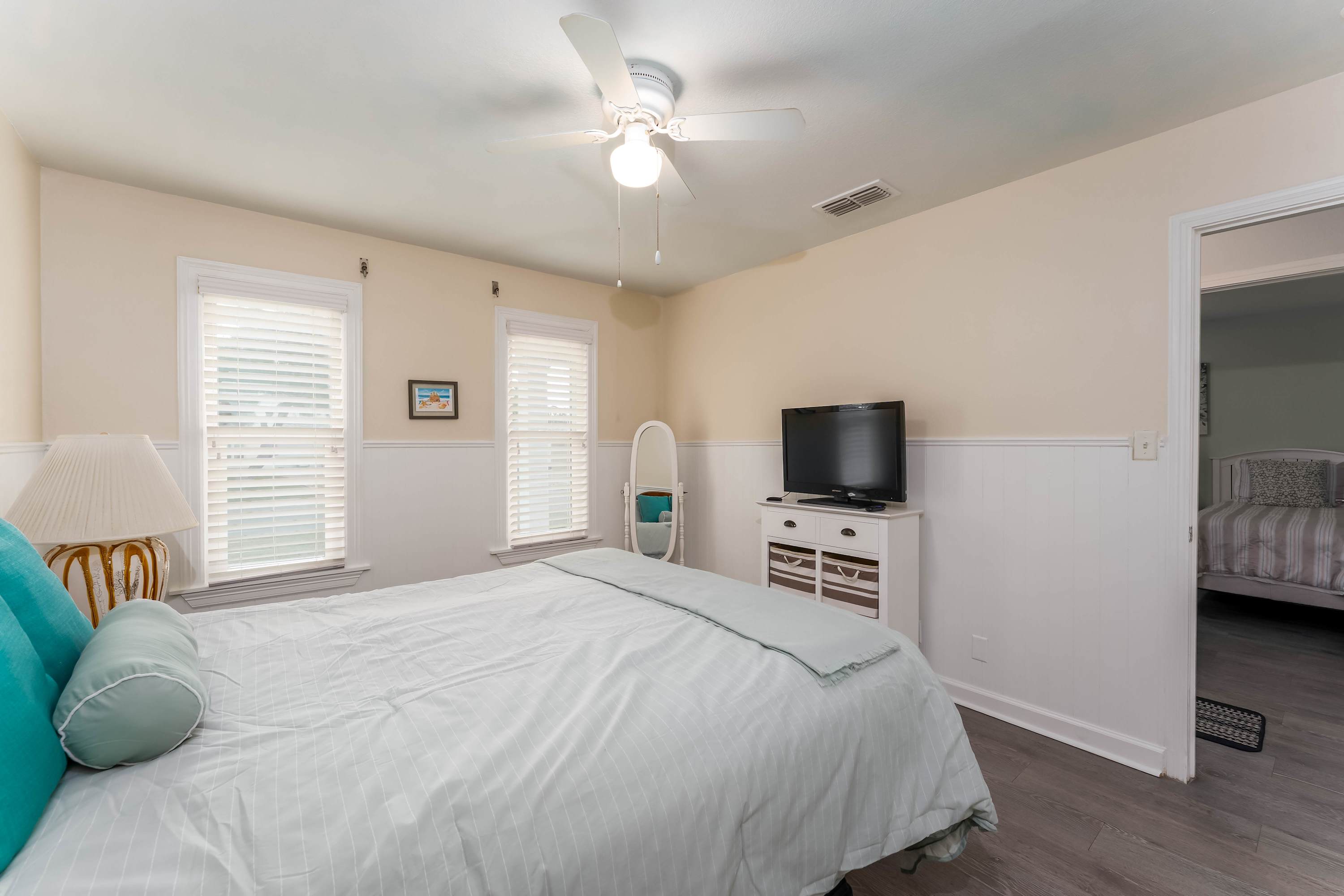 Queen Bedroom with TV — Comfortable queen bed and private access to the patio deck—perfect for morning views of the water.
