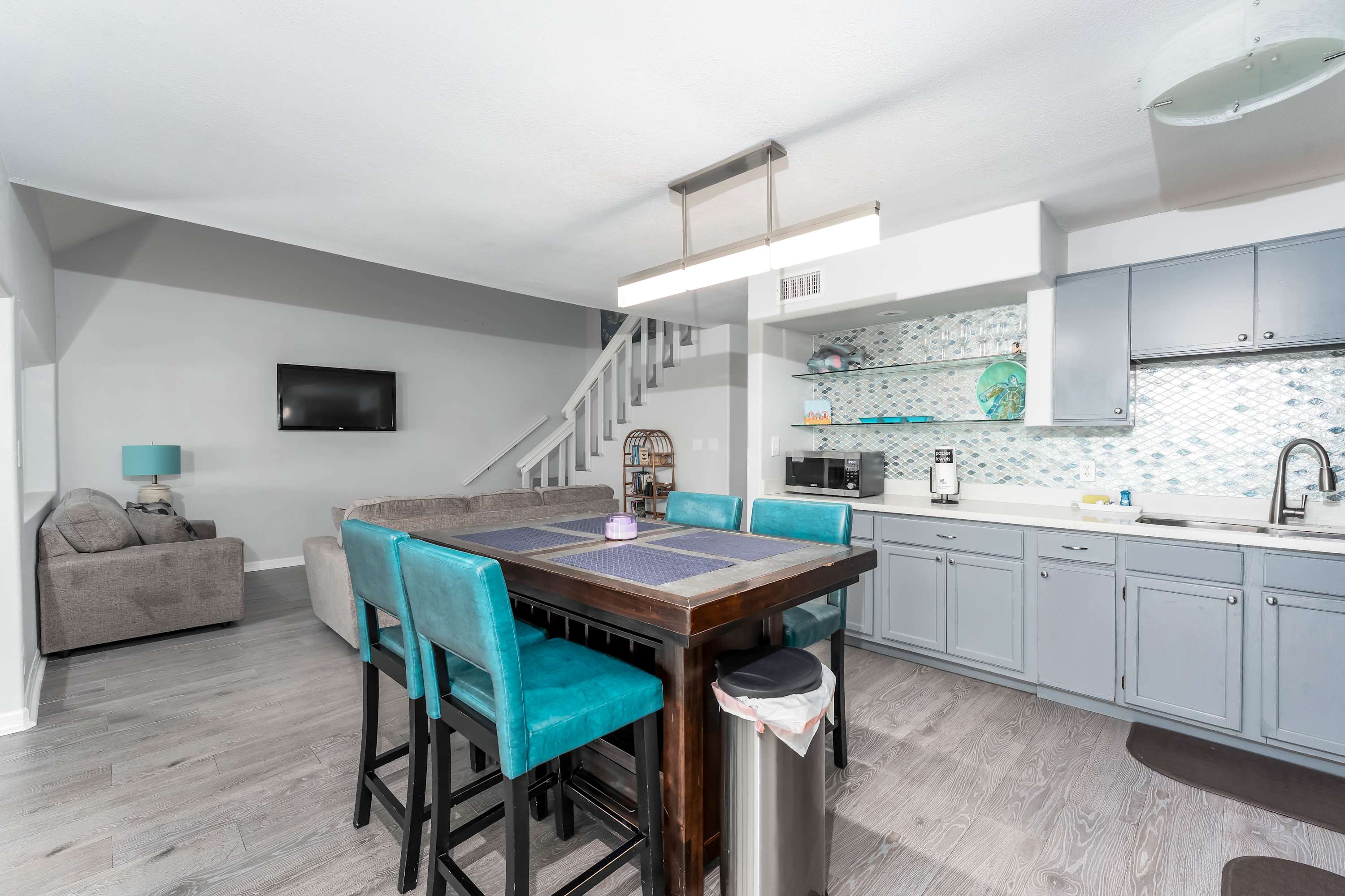 Coastal-Inspired Dining Area — Gather for meals at the stylish island-style dining bar with turquoise accents and seating for four.