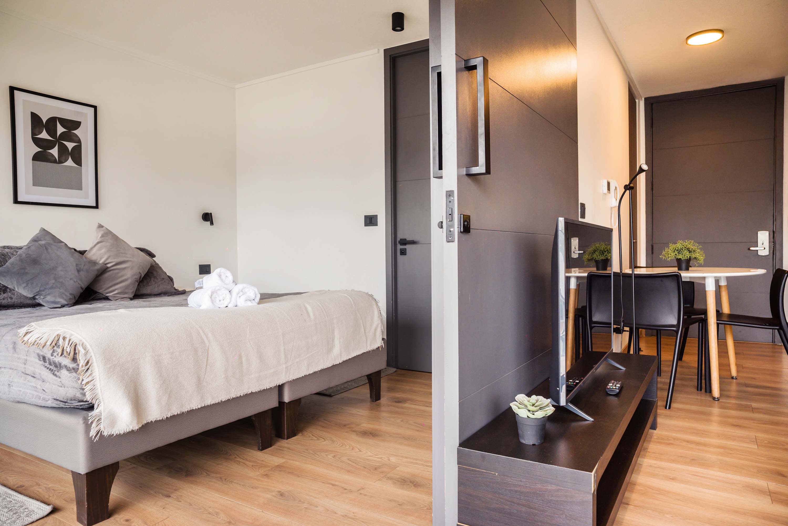 Relax in this cozy bedroom with a comfy bed and modern dining area, perfect for unwinding after exploring the city.