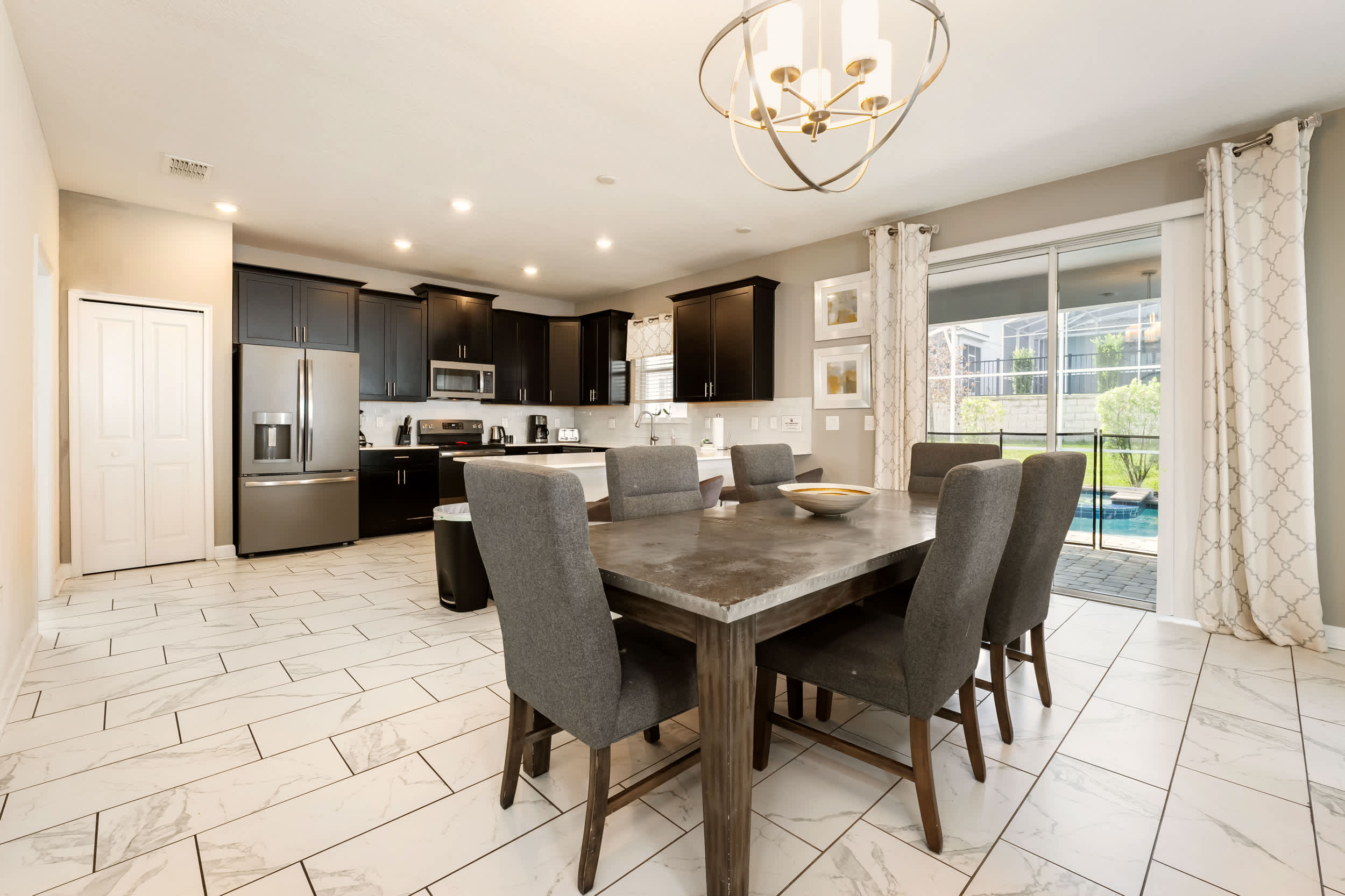 Enjoy meals in this stylish dining area with pool views, perfect for gatherings.