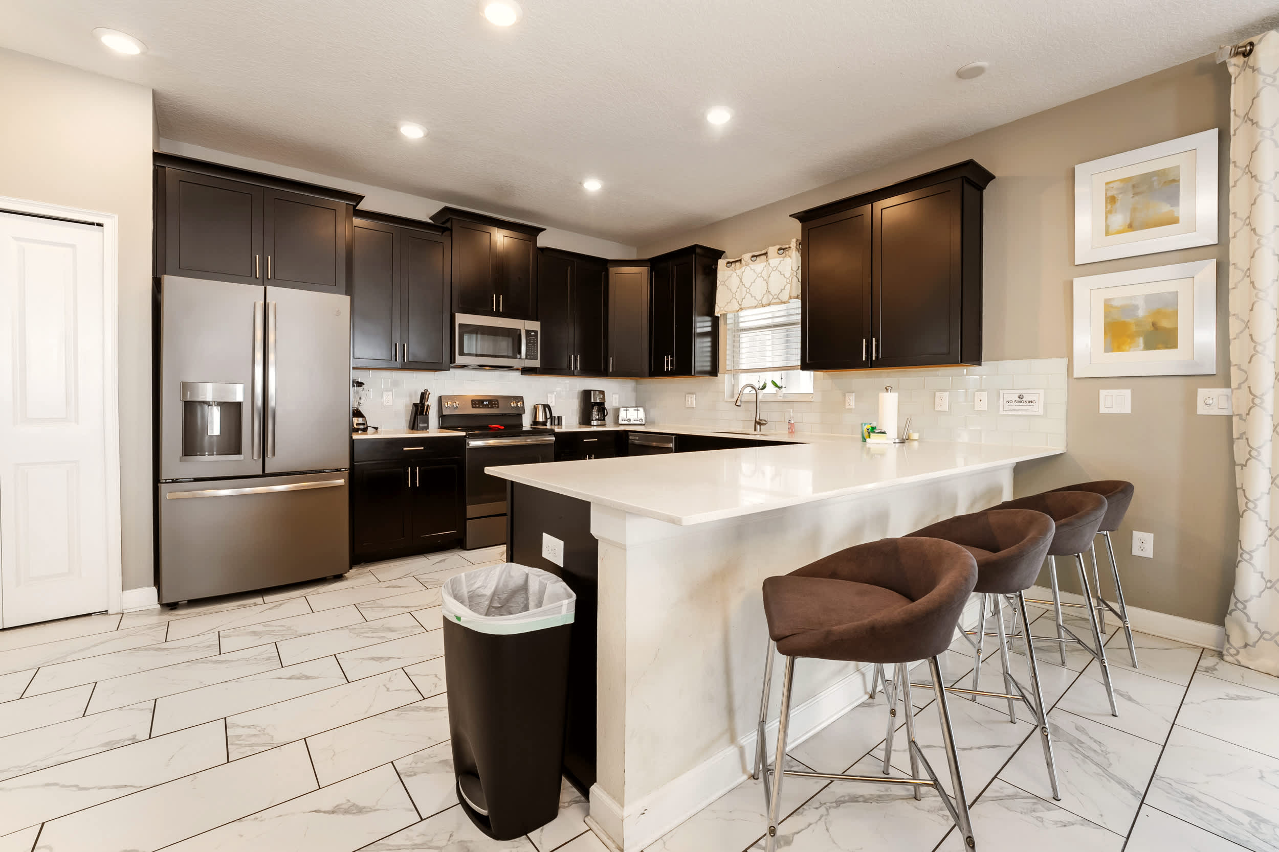 Spacious modern kitchen with sleek appliances and a cozy breakfast bar, perfect for family gatherings.