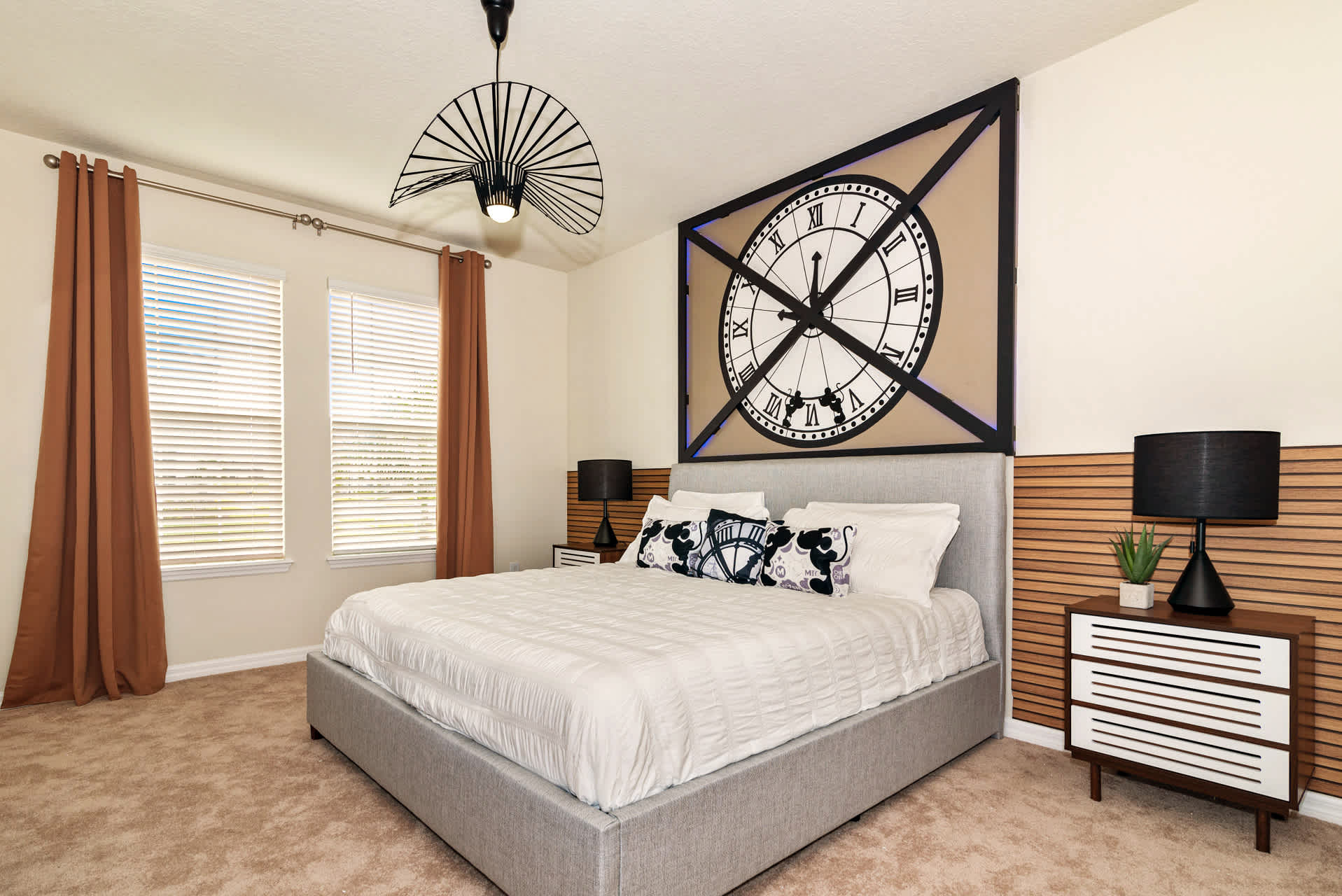 Relax in this stylish bedroom with a unique clock feature and cozy bedding, perfect for a restful stay.