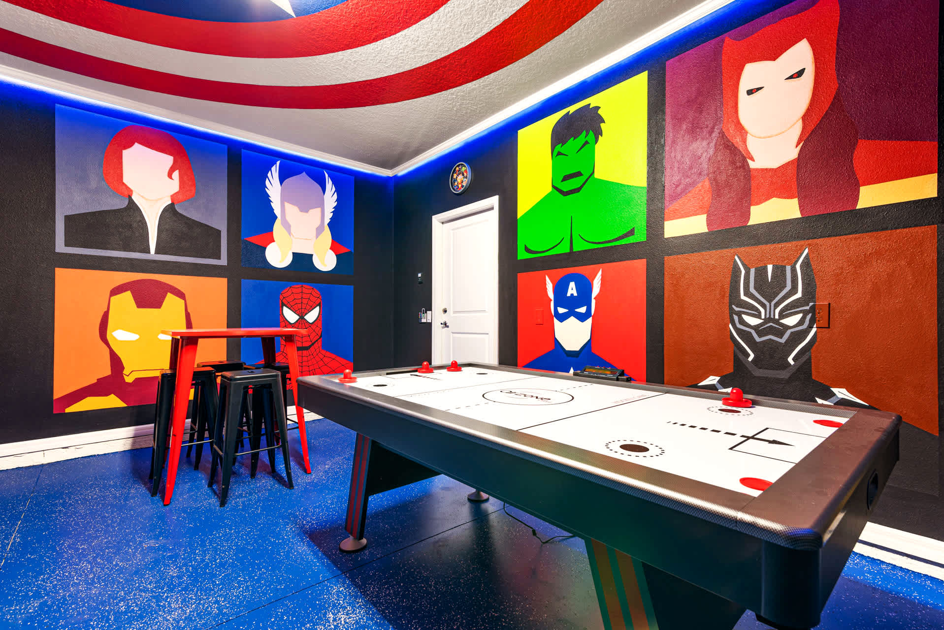 Experience the ultimate superhero-themed game room with air hockey and vibrant murals, perfect for fun-filled family nights.