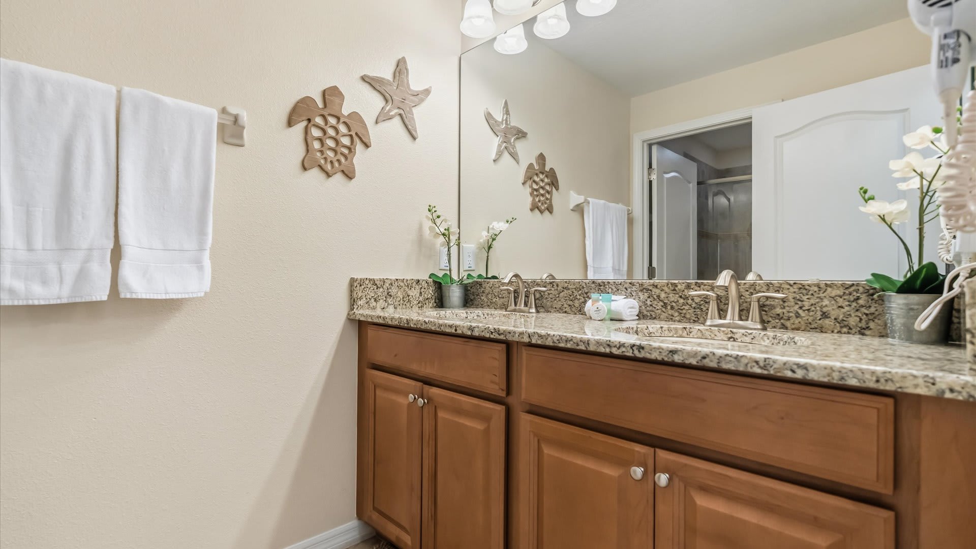 Full bathroom with granite countertops and dual sinks.