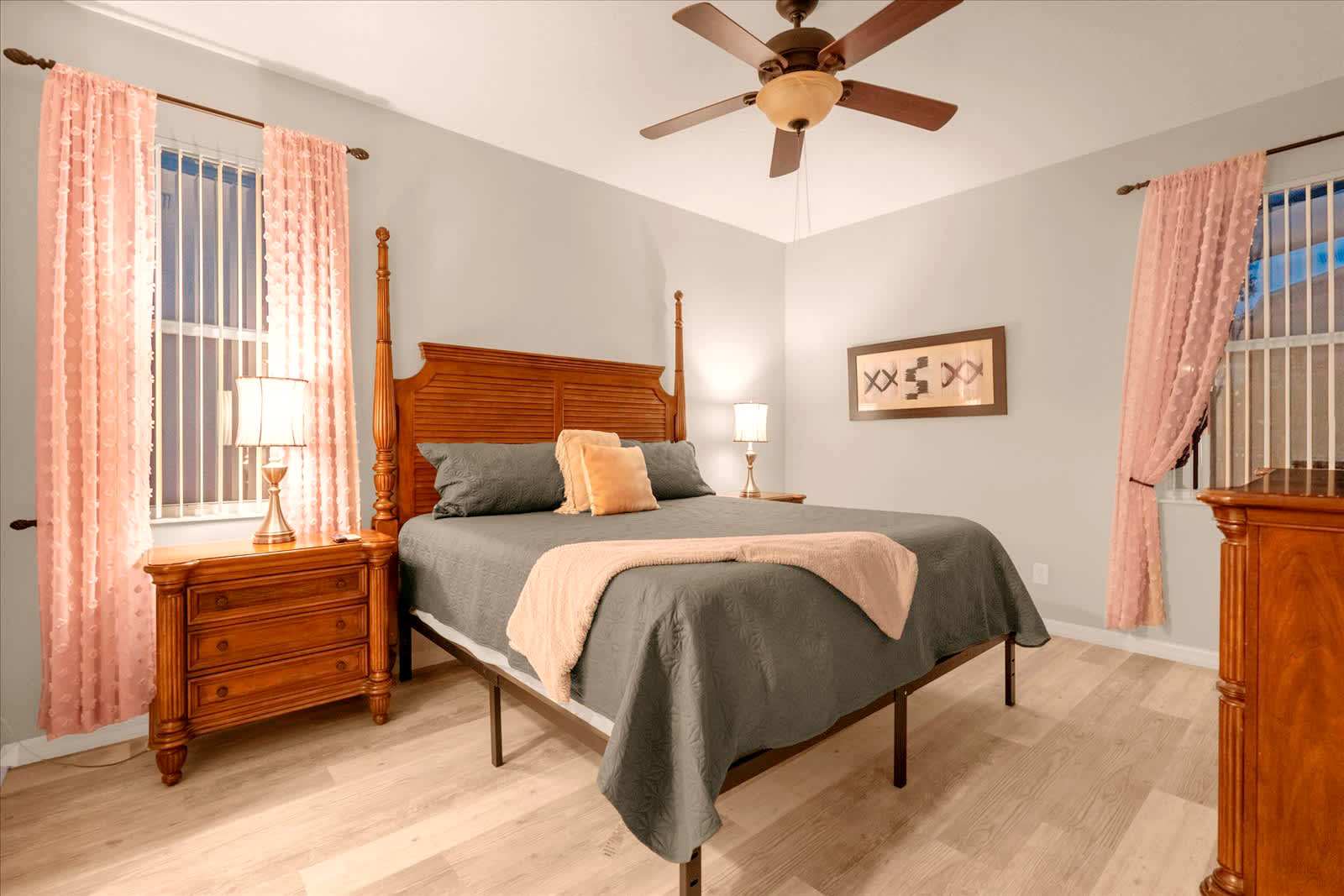Relax in this cozy bedroom with elegant wooden furnishings and soft lighting, perfect for a restful night's sleep.
