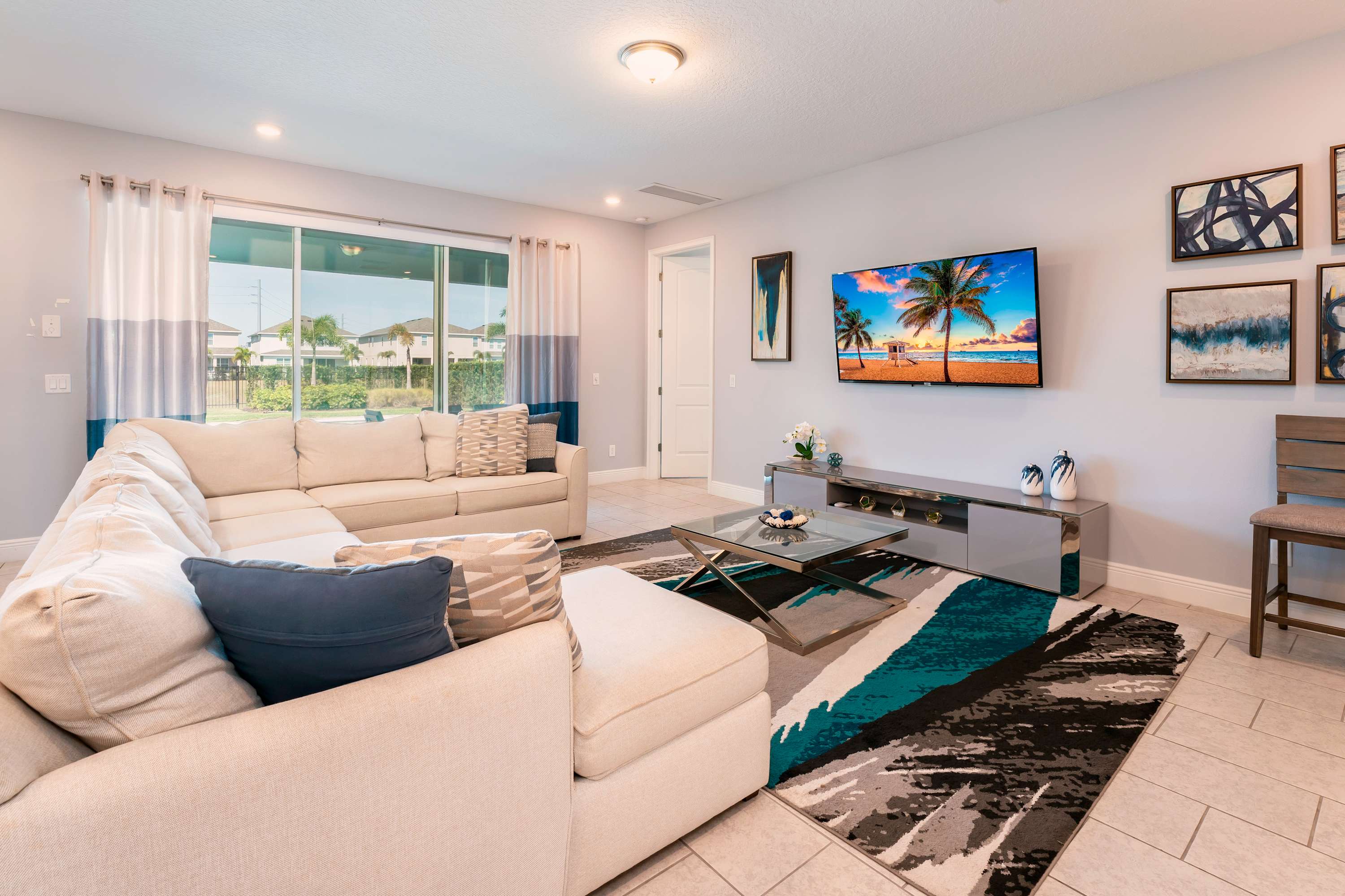 Relax in this stylish living room with a plush sectional, vibrant decor, and a stunning view, perfect for unwinding after a day of exploring.