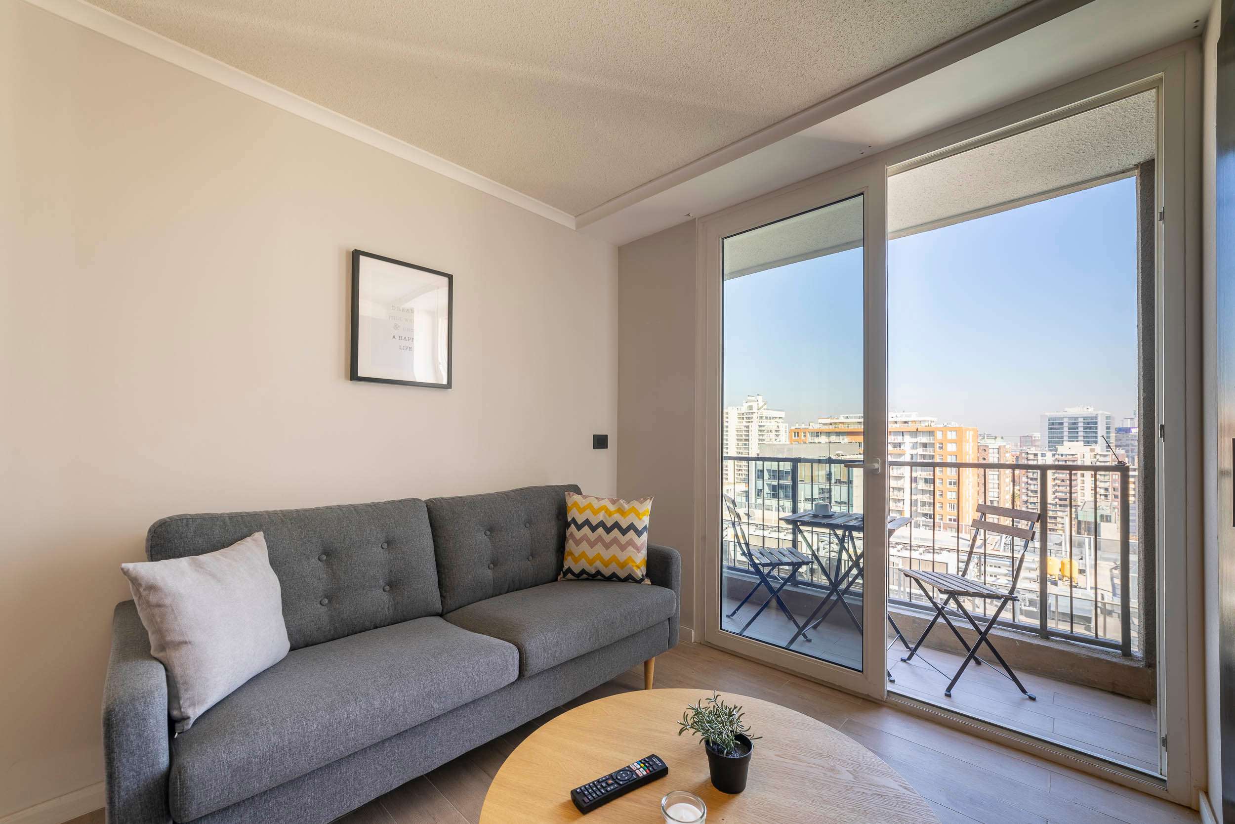 Relax in this cozy living space with a private balcony offering stunning city views. Perfect for unwinding after a day of exploring.
