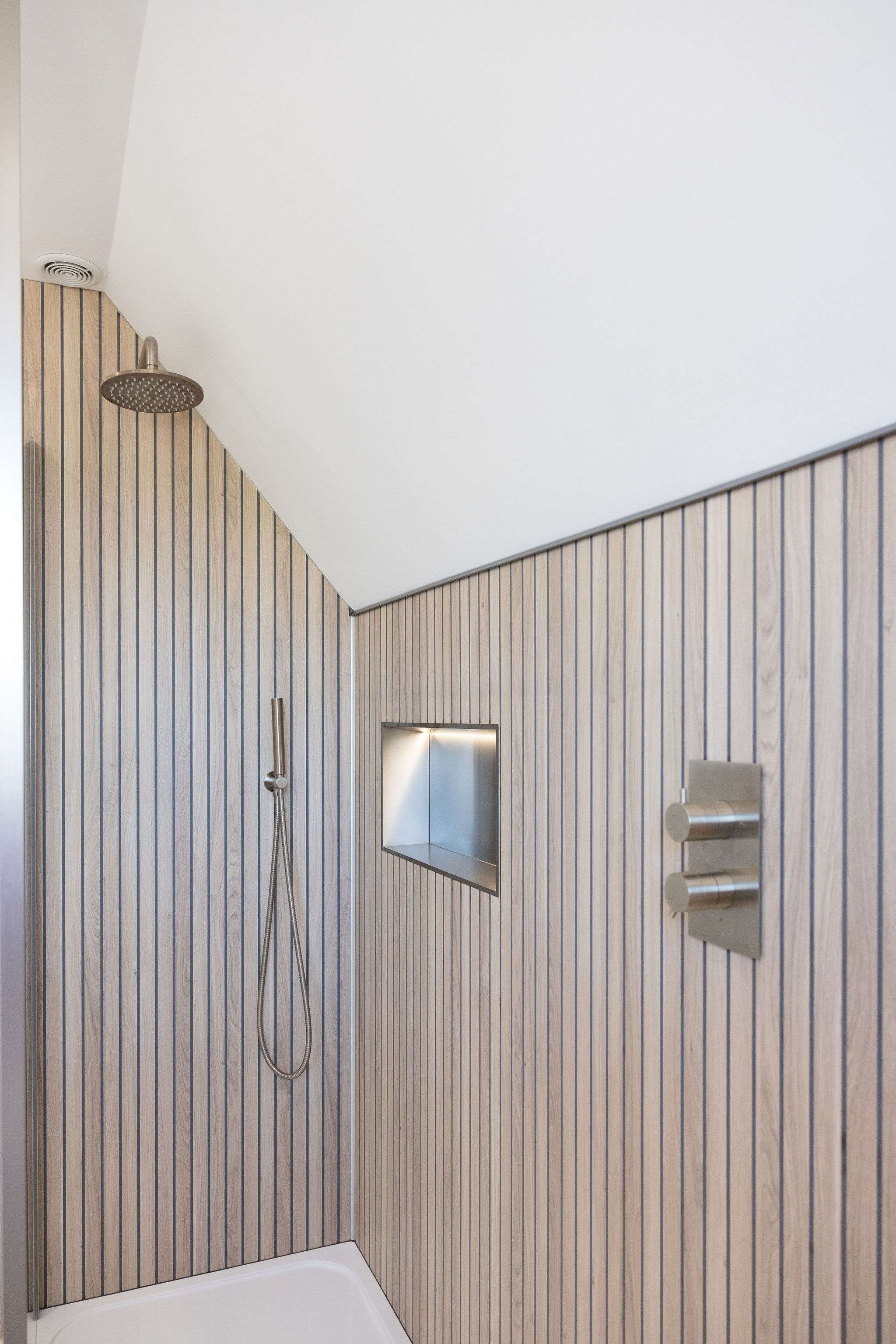 An easily accessible walk-in shower, with overhead and handheld shower heads.