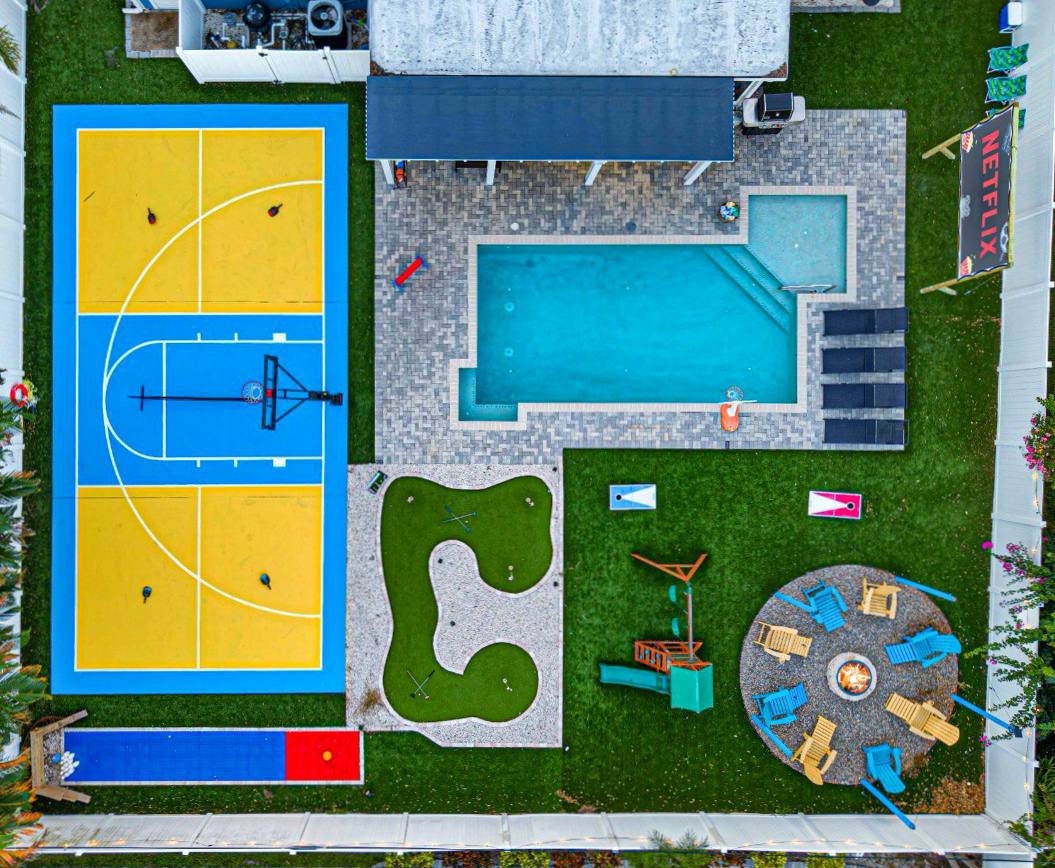 Largo, FL Airbnb with heated saltwater pool, 15 minutes to Gulf beaches! Enjoy a full basketball + pickleball court, mini golf, lawn bowling, kids’ playground/swing set, and private outdoor movie theater right from the pool. Perfect for family trips!