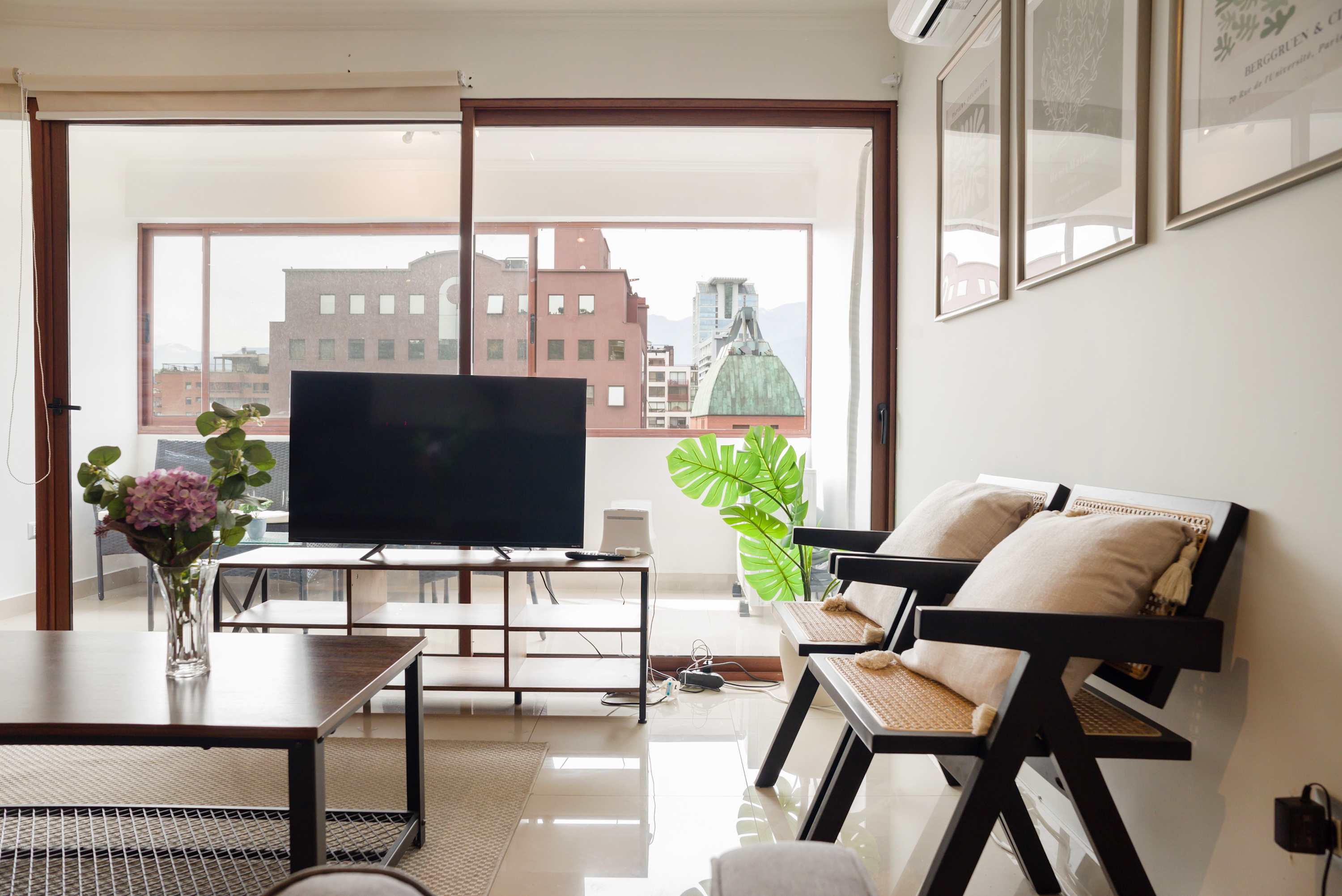Enjoy city views from this modern living room with cozy seating and stylish decor.