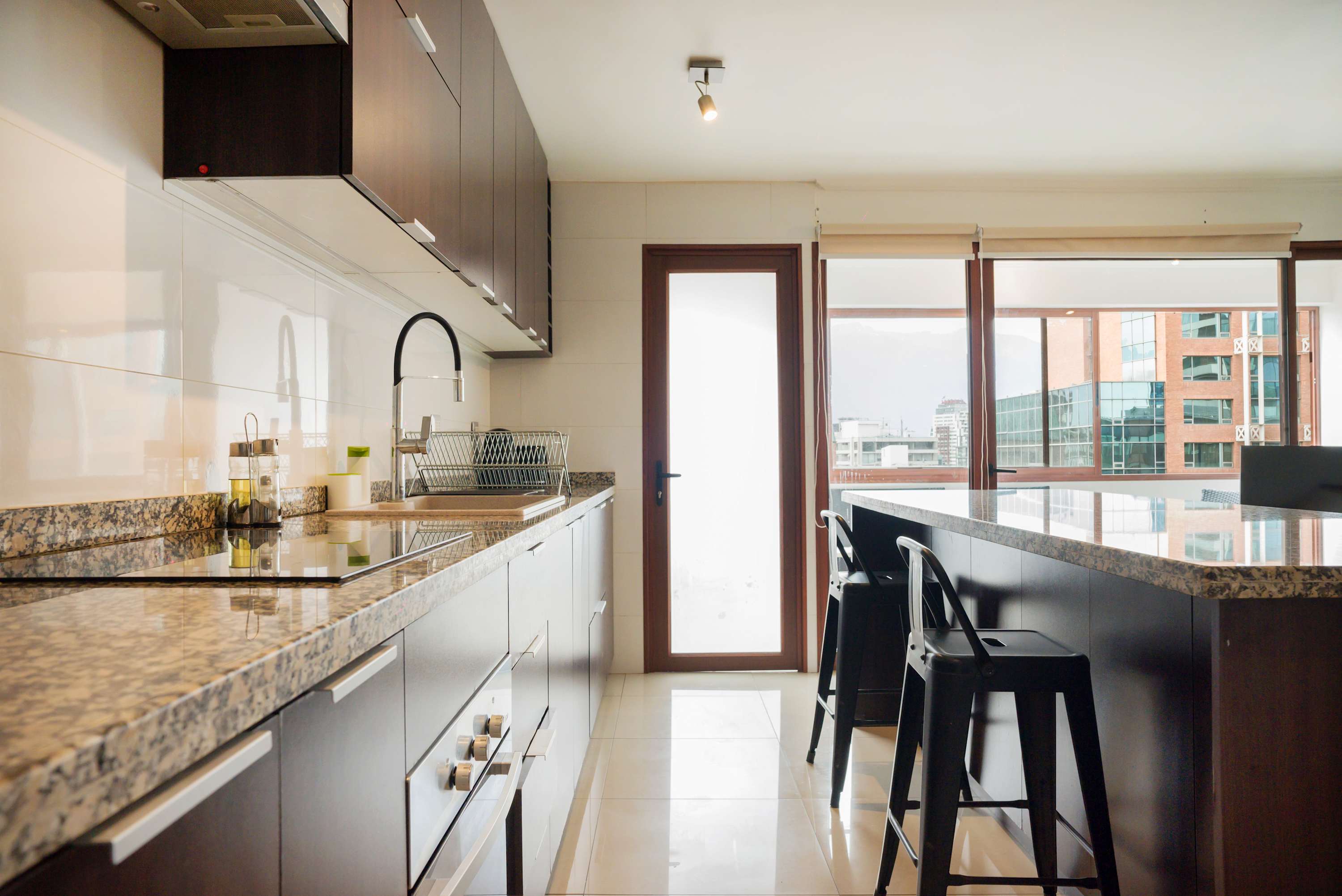 Bright and modern kitchen with sleek granite countertops and a spacious island, ideal for culinary creations.