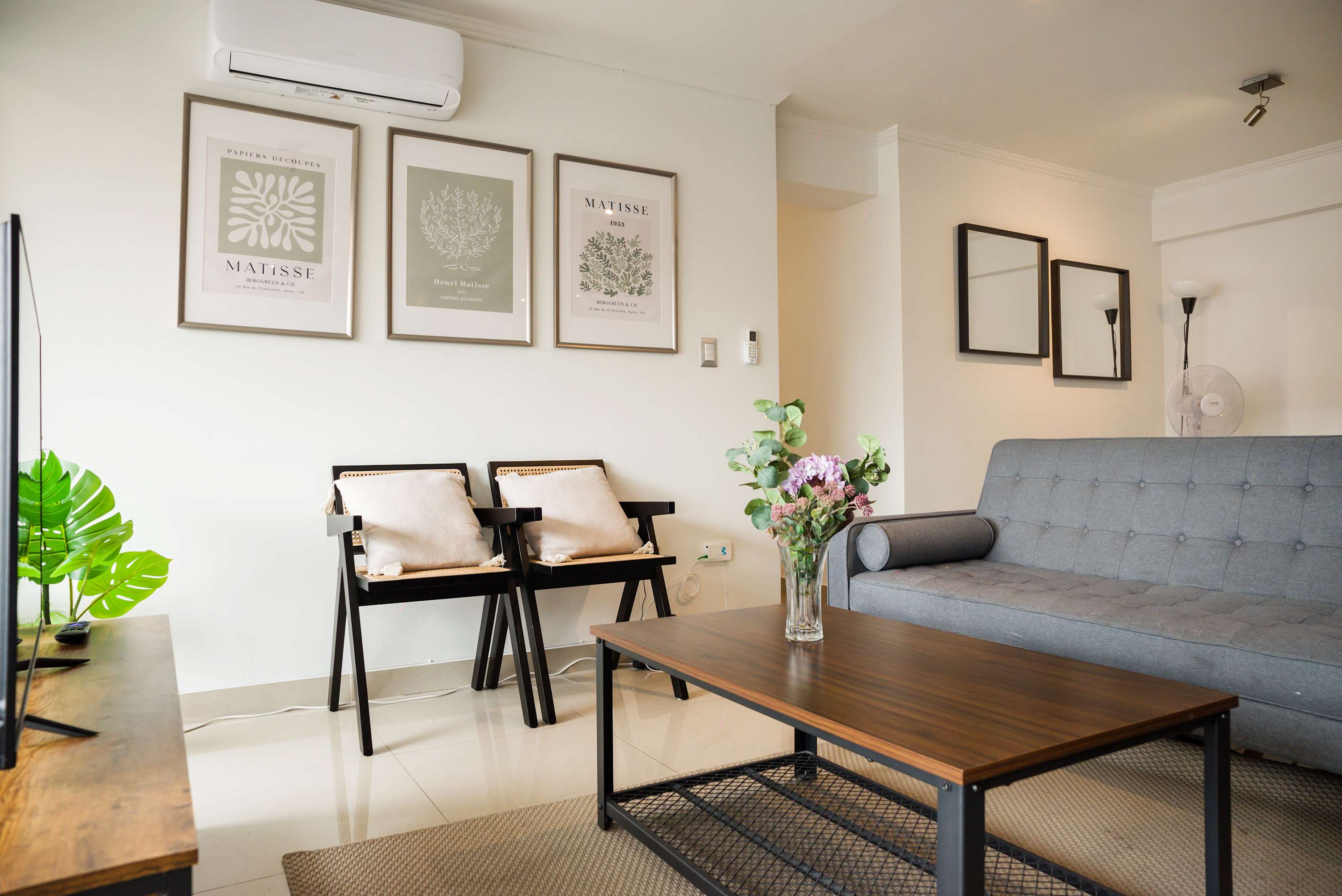 Stylish living room with modern decor, natural light, and cozy seating, perfect for relaxation.