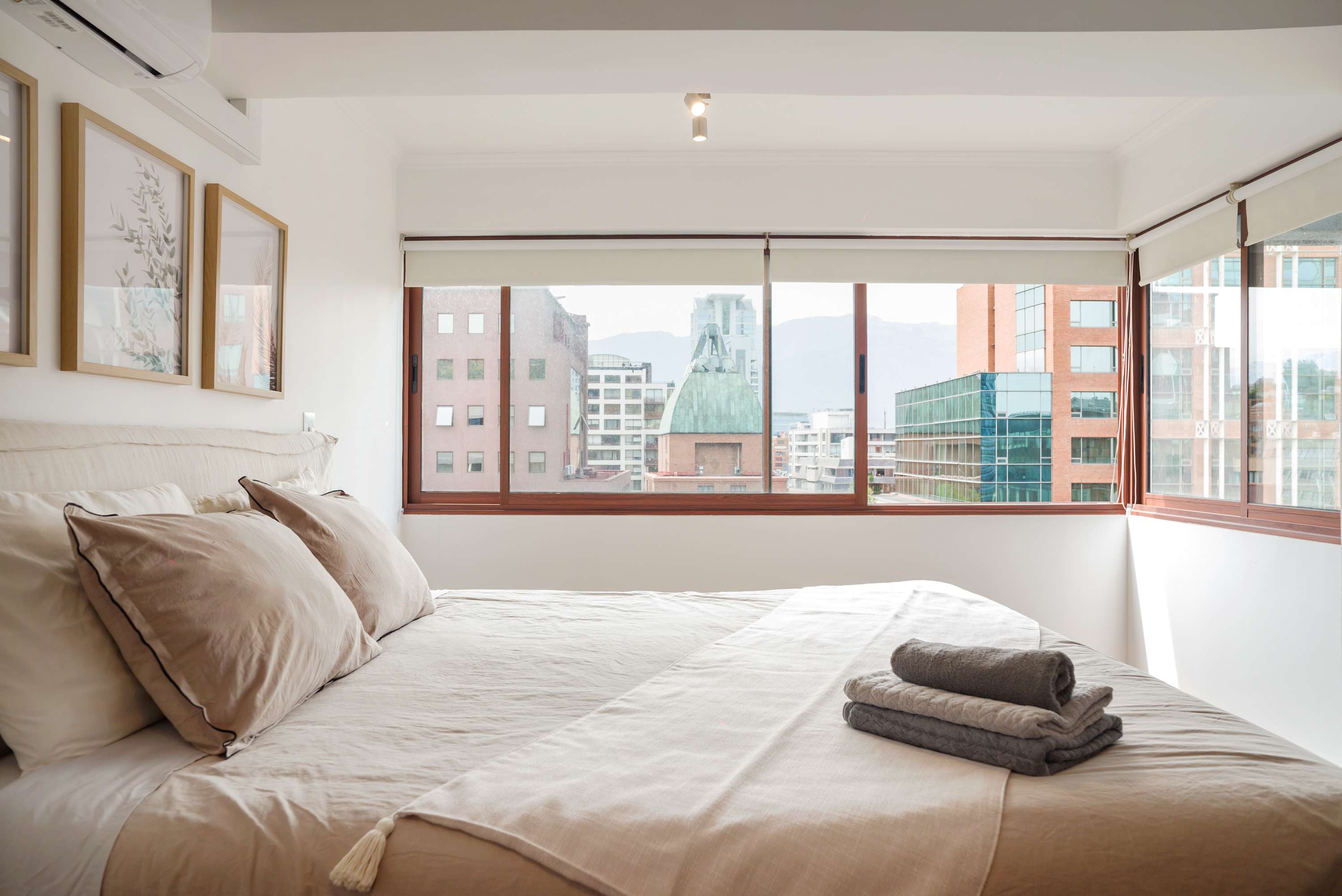 Enjoy breathtaking city views and natural light in this cozy bedroom retreat, perfect for relaxation.