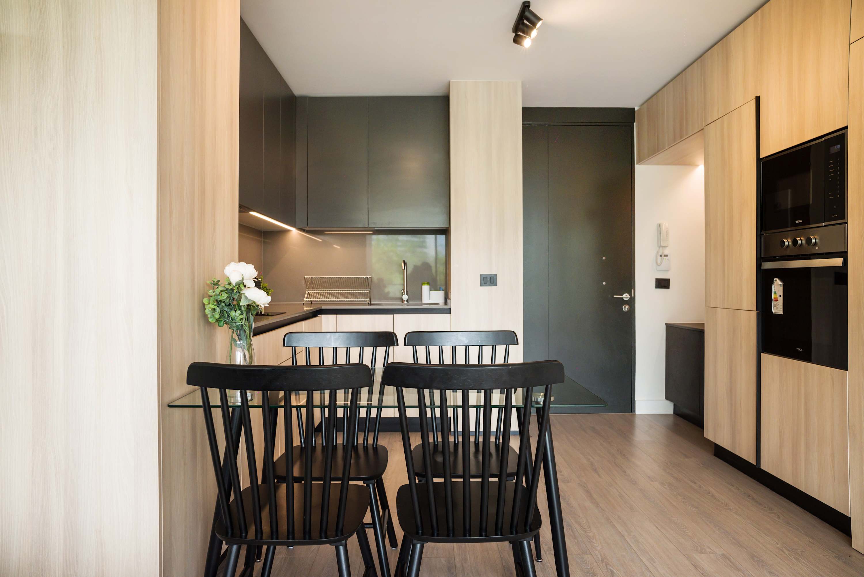 Modern kitchen with sleek design and cozy dining area, perfect for intimate meals in a stylish setting.