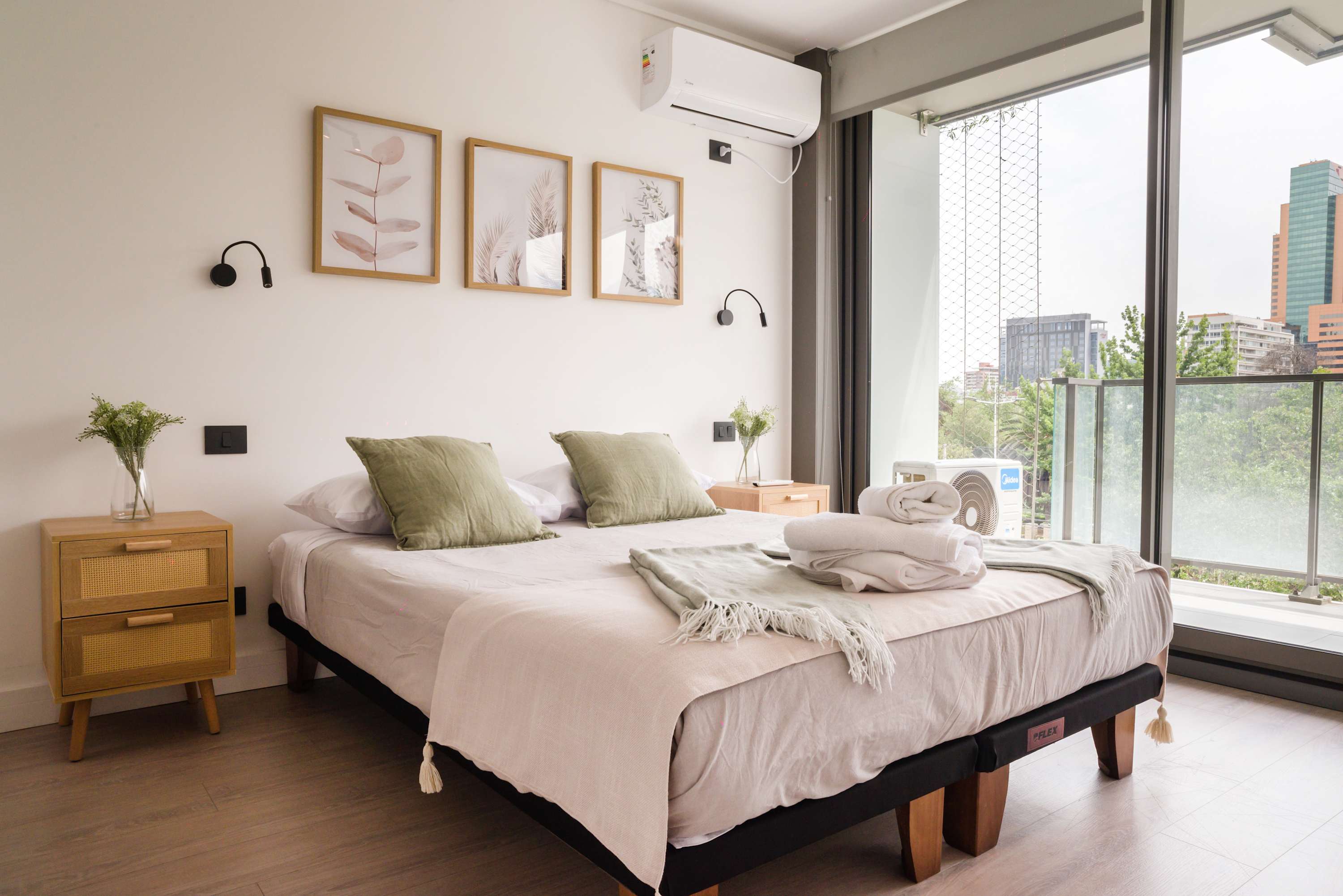 Relax in this chic bedroom with a comfy bed, modern decor, and stunning city views. Perfect for a serene getaway.