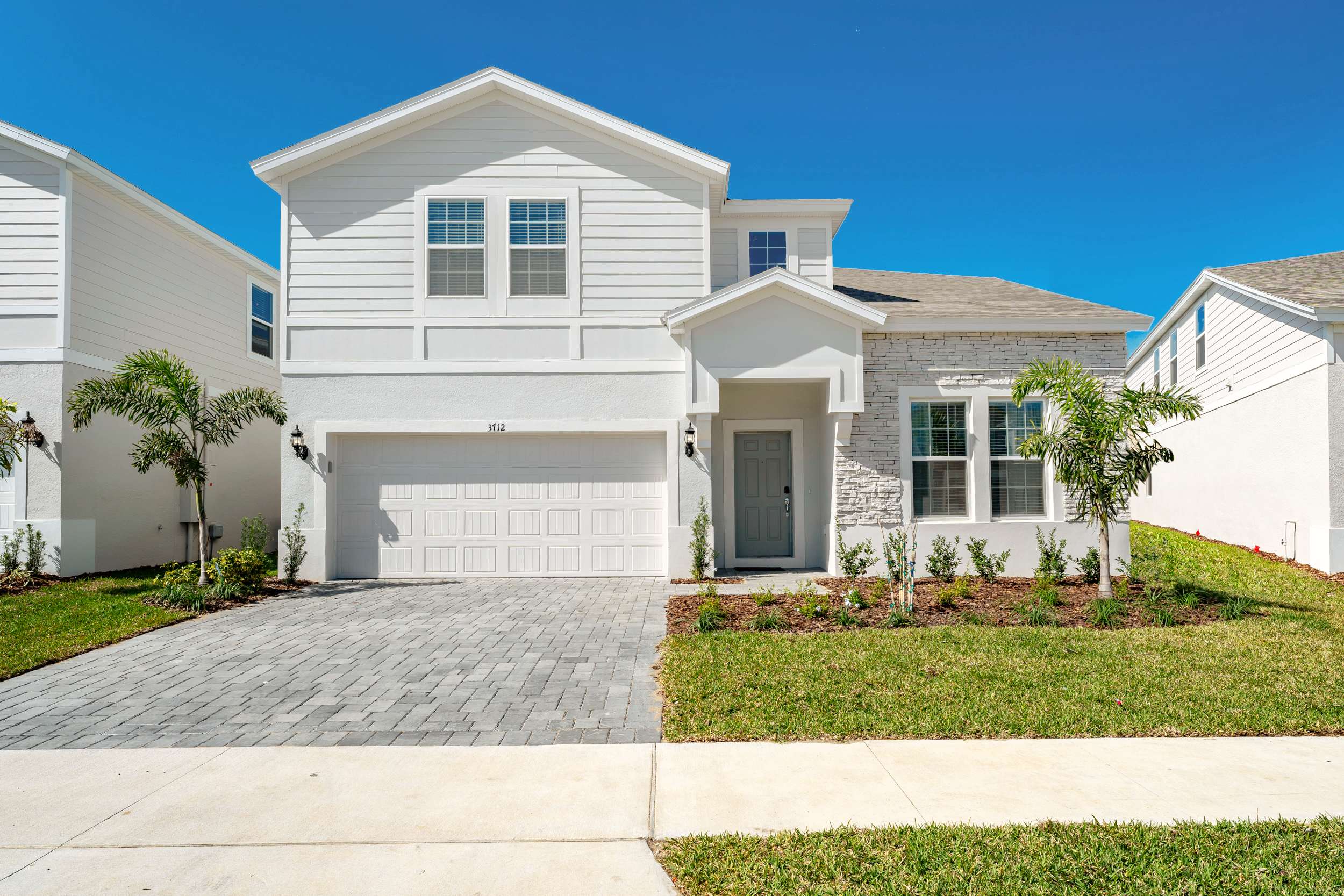 Stunning modern villa with spacious garage and pristine landscaping, perfect for a luxurious getaway.